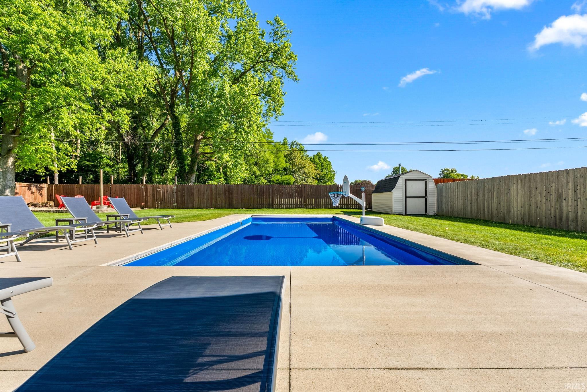 In-ground swimming pool with a concrete surround