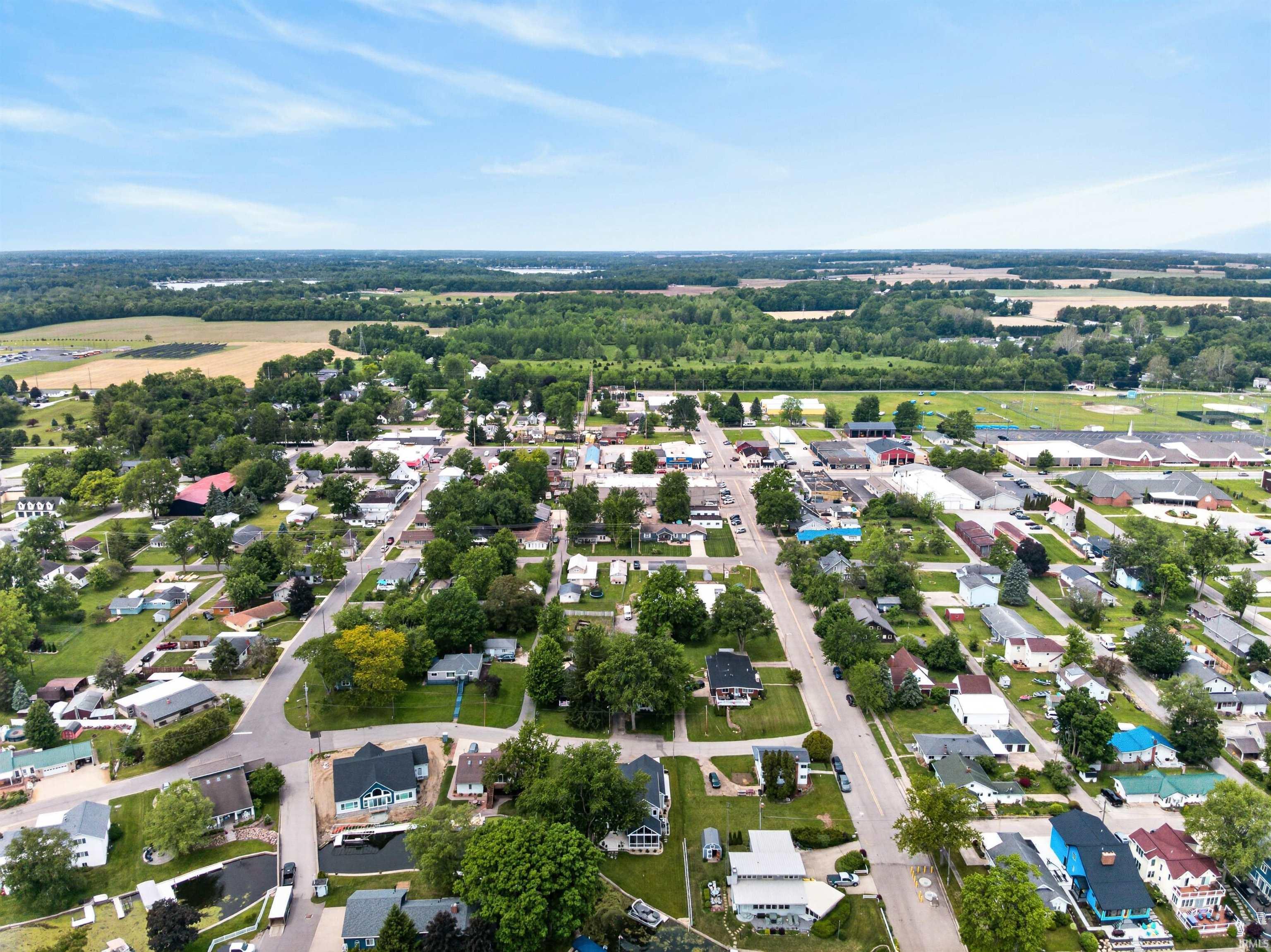 Aerial perspective showcasing a residential community with abundant mature trees and a mix of single-family homes