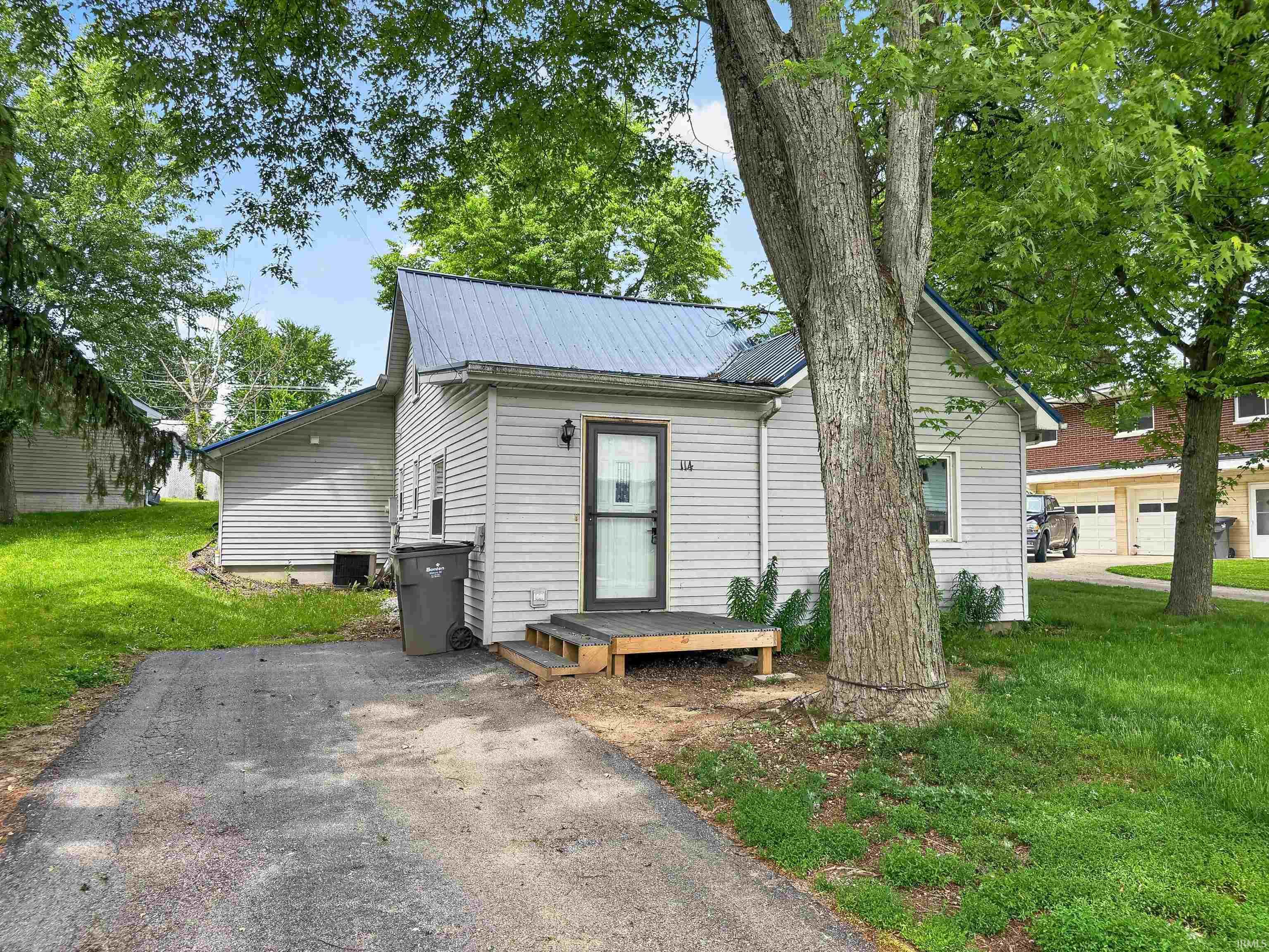 Light-colored siding exterior with a metal roof
