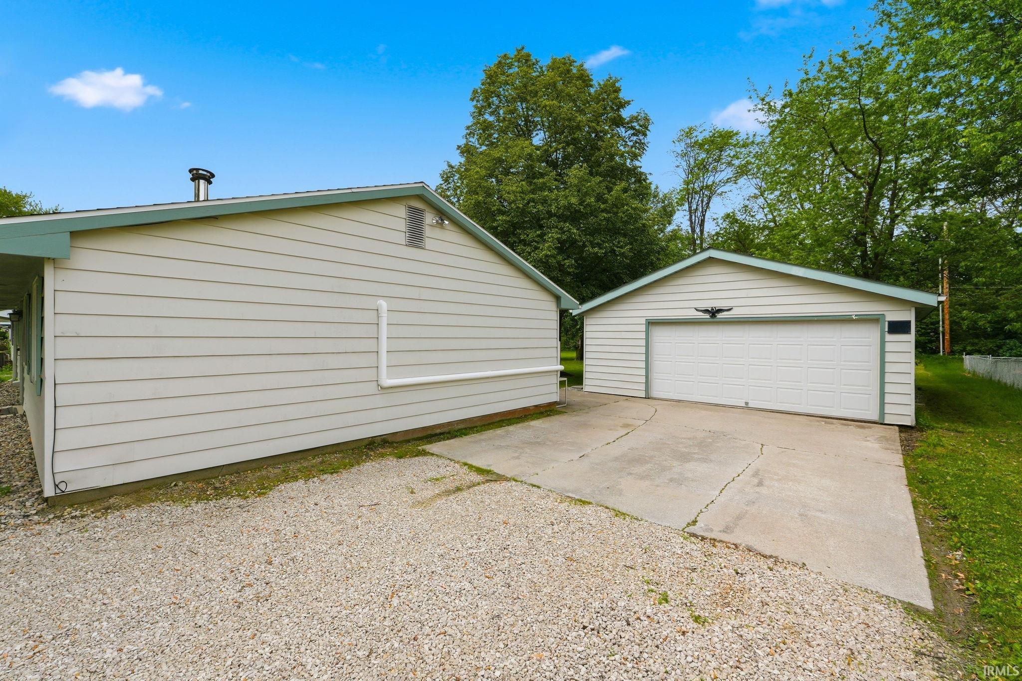 Detached garage with a single vehicle door and concrete driveway