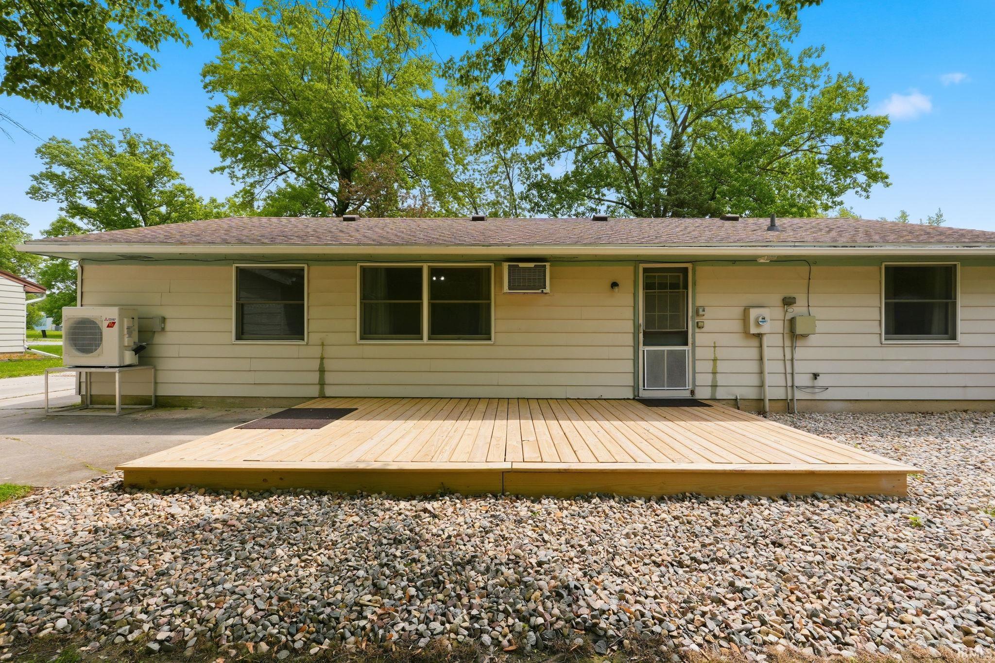 Expansive rear deck featuring light-toned wood planks, offering an outdoor living area
