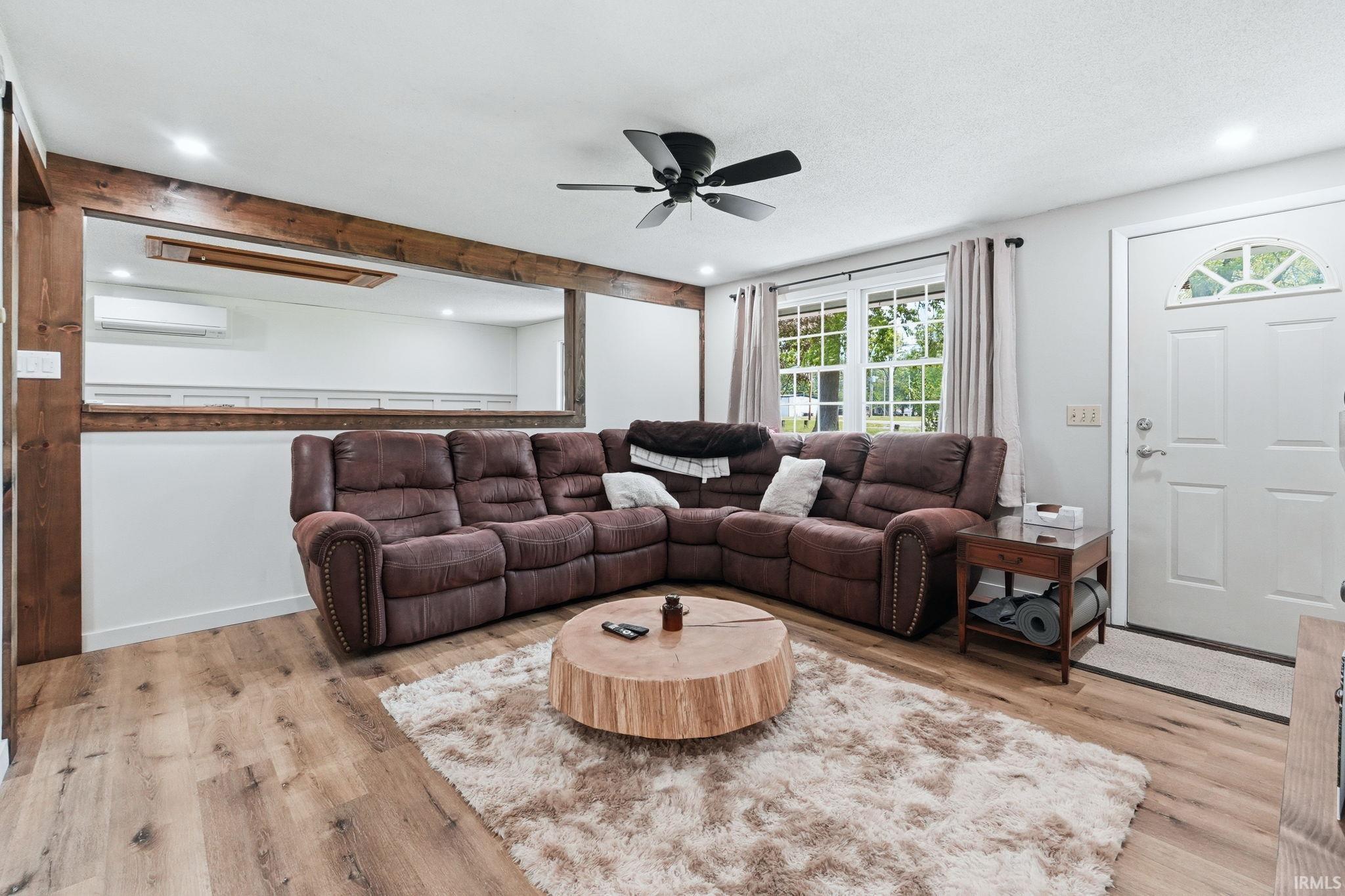Living space featuring wood-finish flooring, recessed lighting, and a ceiling fan