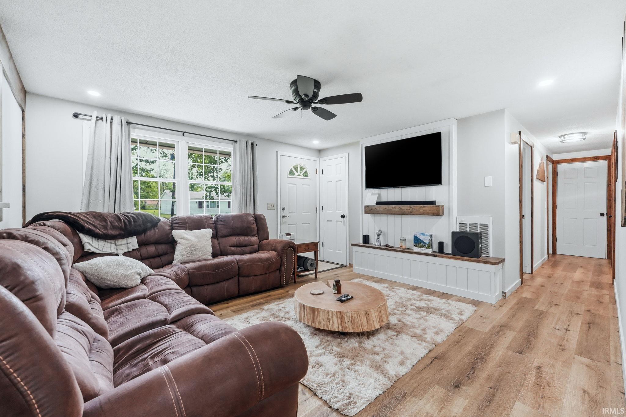 Living area featuring wood-finish flooring, recessed lighting, and a ceiling fan