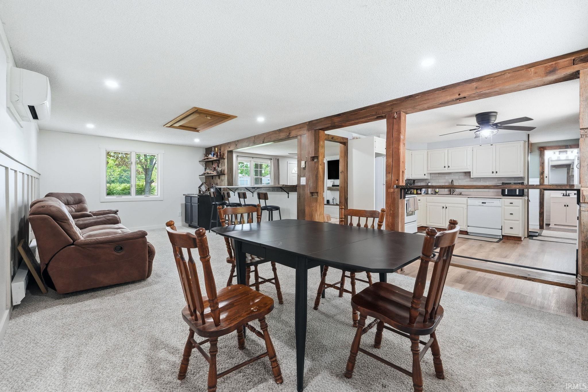 Carpeted living area featuring wainscoting, recessed lighting, and a window