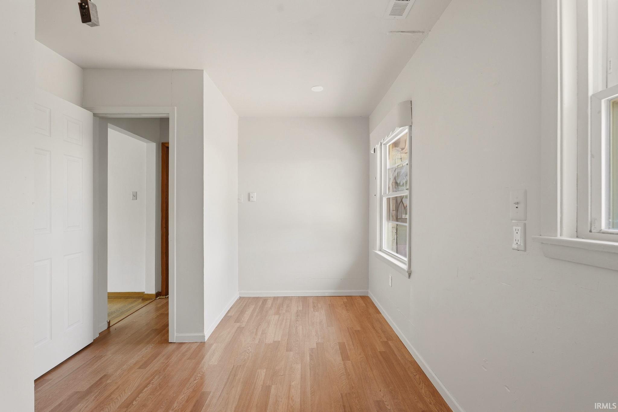 Hardwood flooring spans this room, featuring recessed lighting and multiple windows