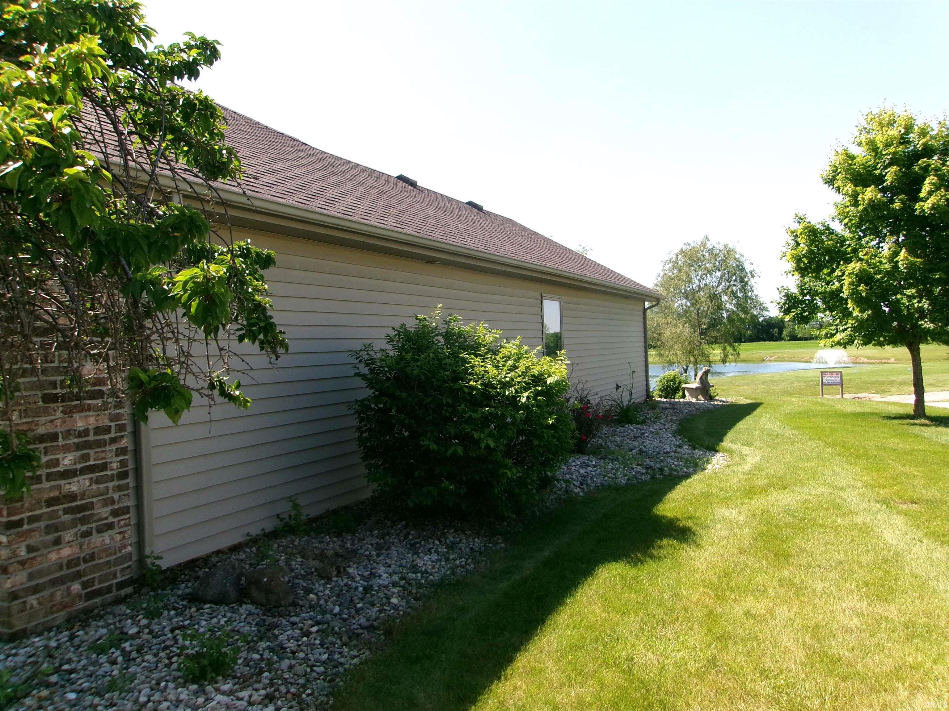 Exterior featuring light-colored siding, a dark-toned shingle roof, and a partial brick facade