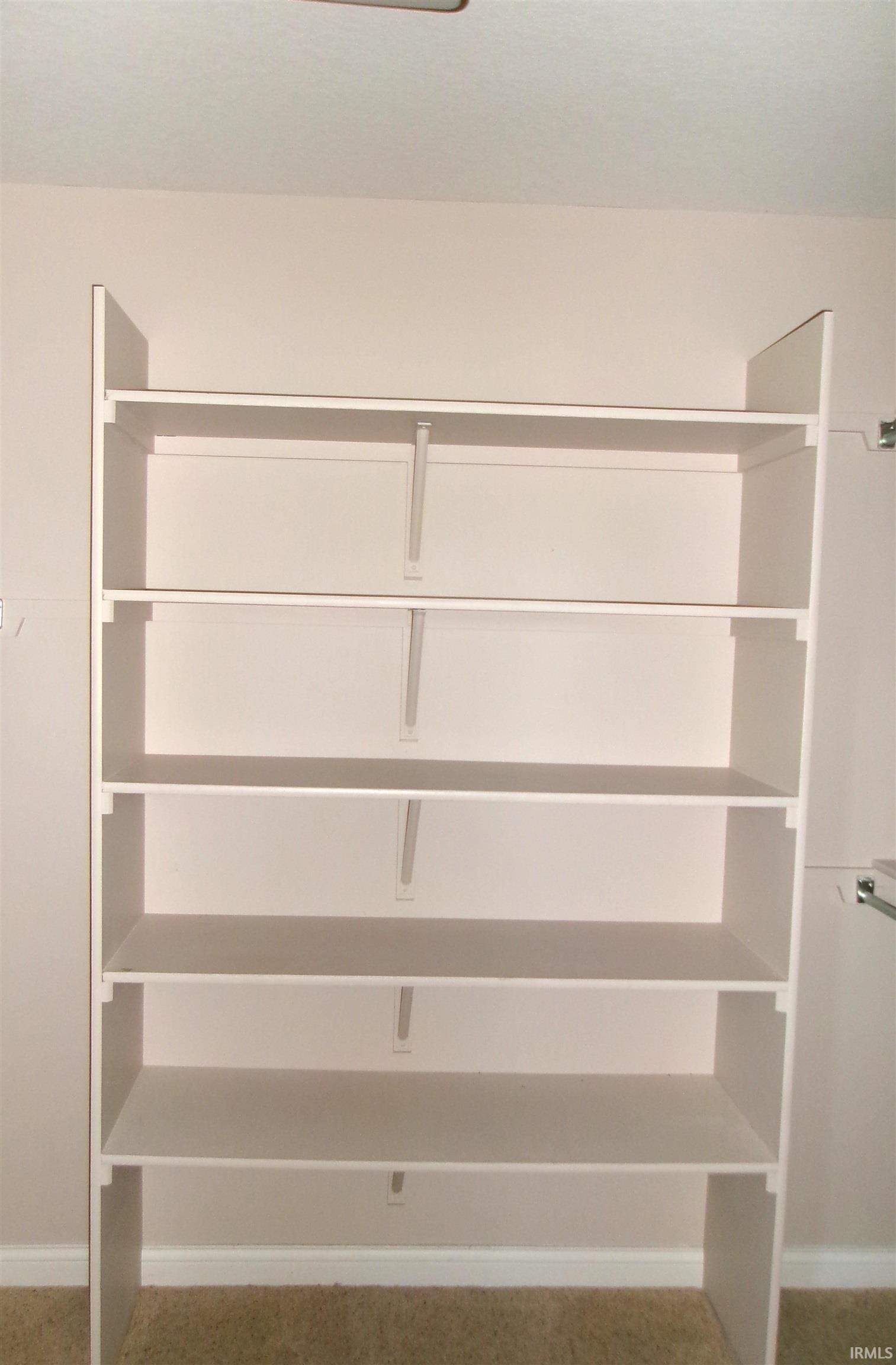 Built-in white shelving system with six tiers, offering extensive storage