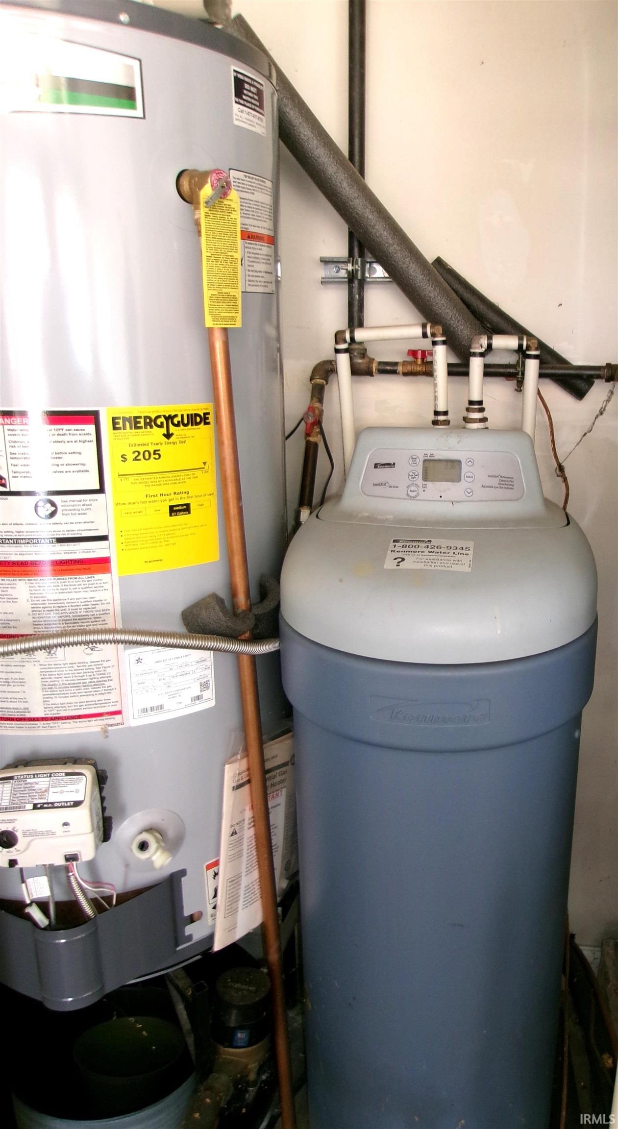 Dedicated utility space featuring a water heater and a water softener system