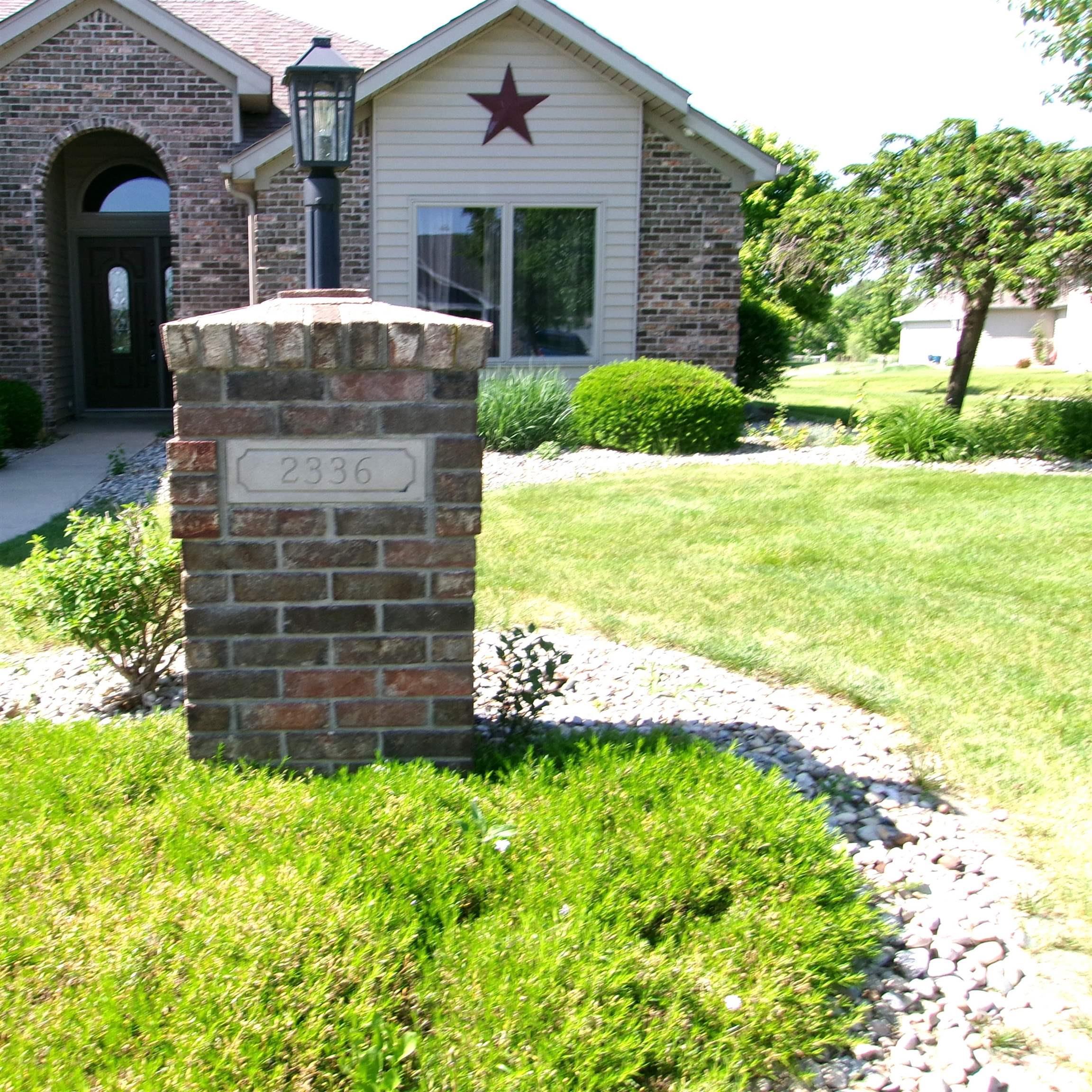 Brick pillar with an integrated lantern, showcasing the property address