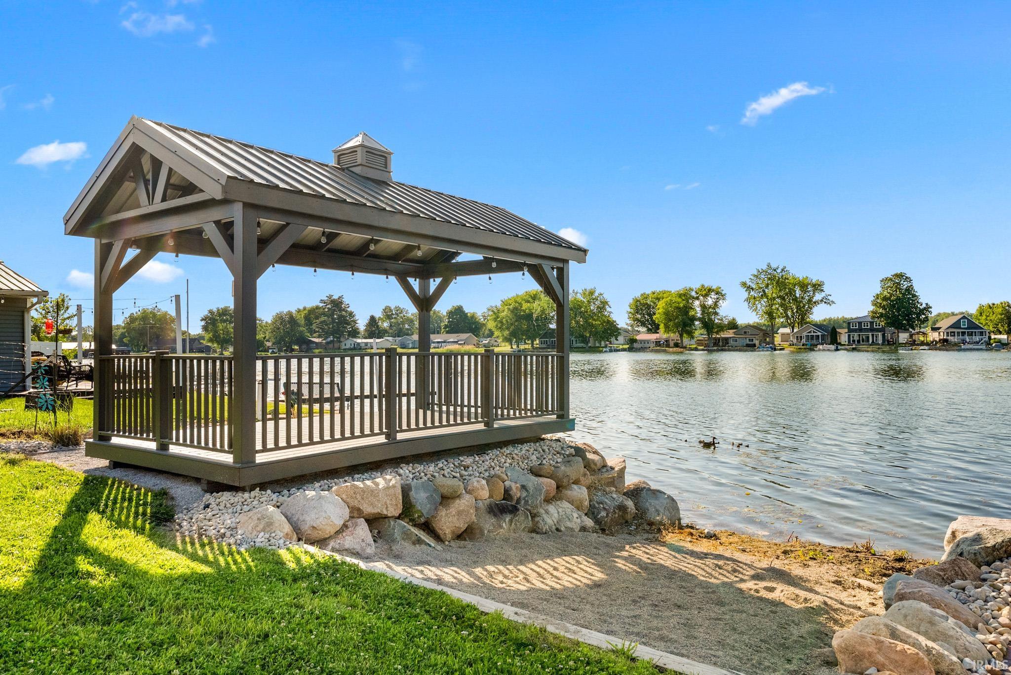 Waterfront gazebo with a metal roof and integrated string lighting