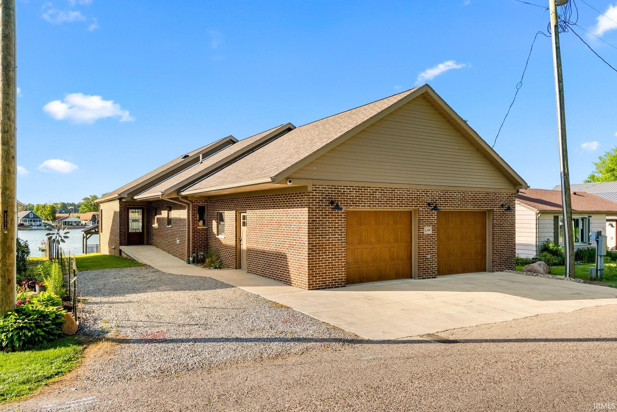 Brick exterior featuring wood-finish garage doors and a paved driveway