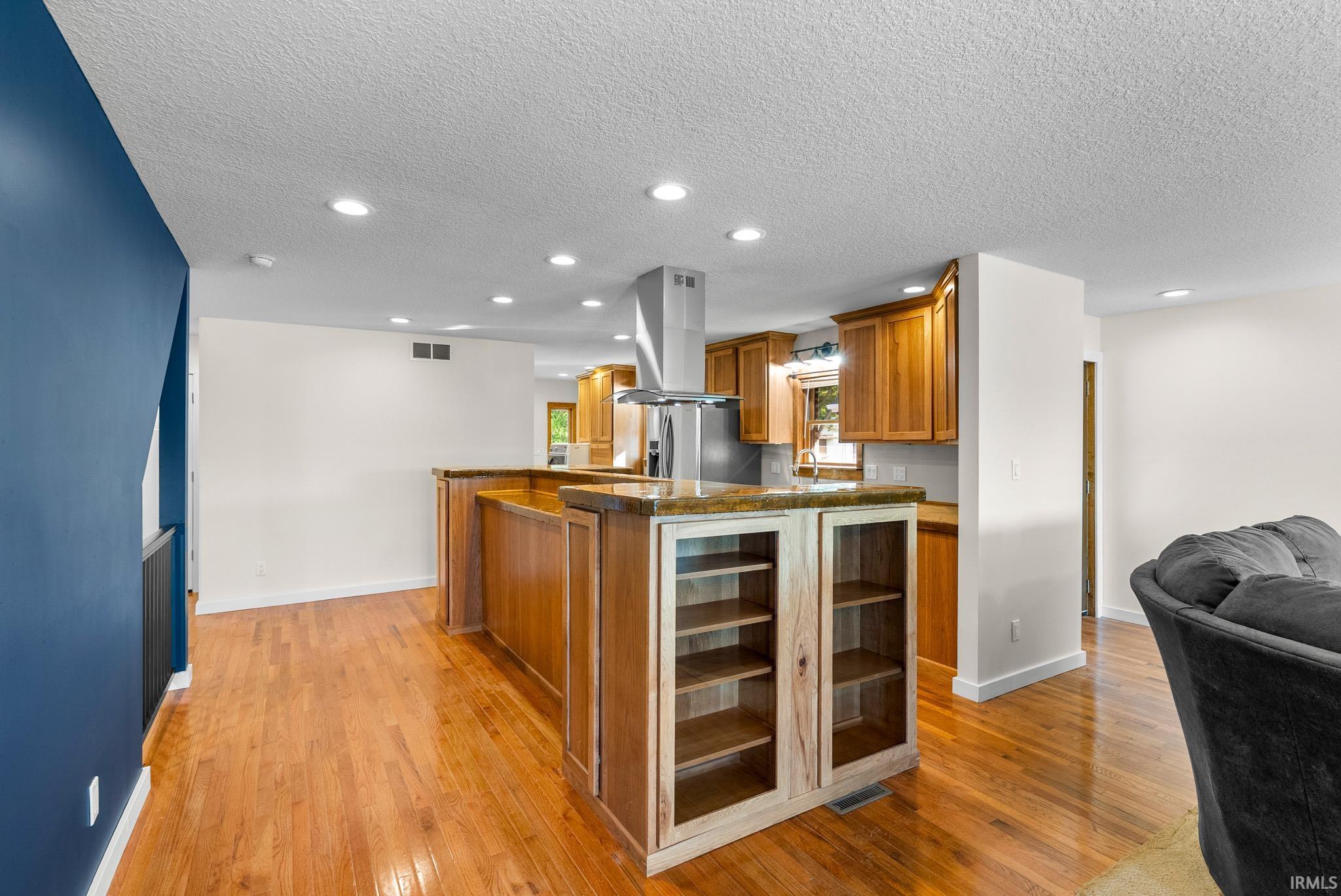 Kitchen island with integrated shelving and glass-front display cabinetry