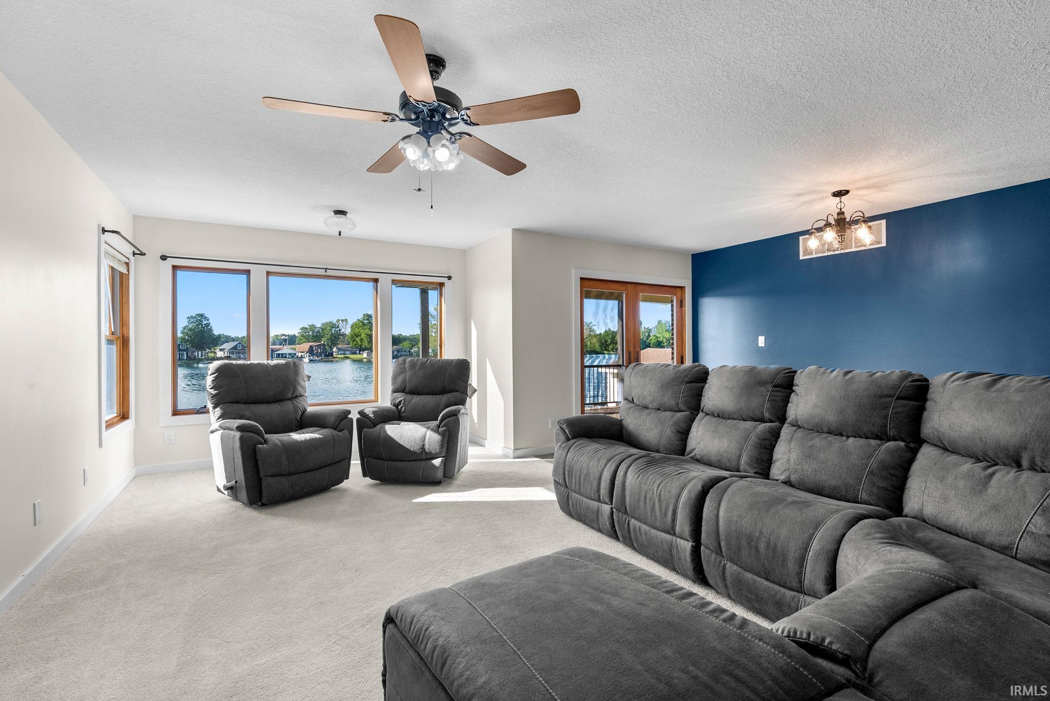 Light-filled interior featuring a ceiling fan with integrated lighting, recessed lighting, and a textured ceiling