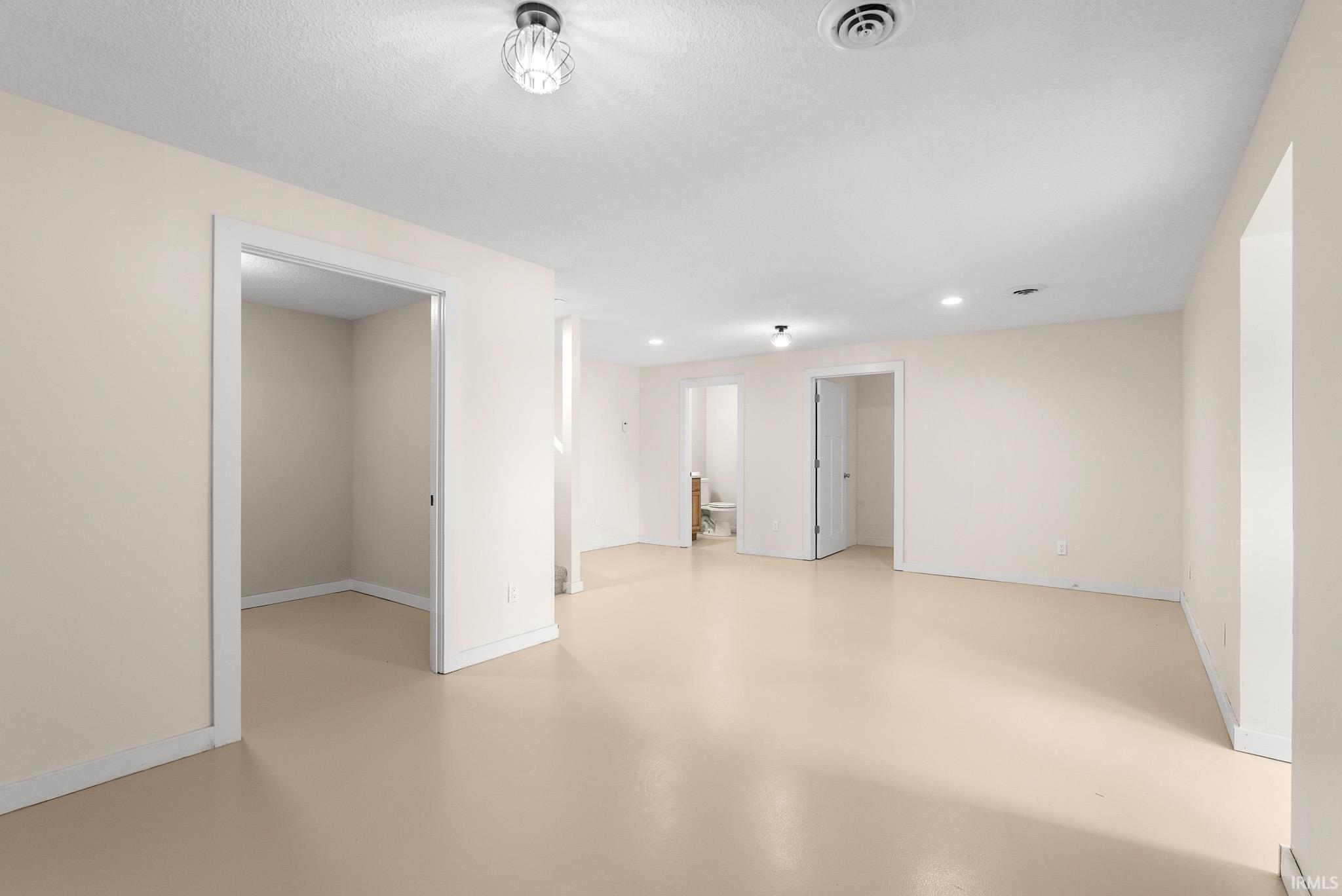 Open concept room with neutral wall paint and light-toned flooring