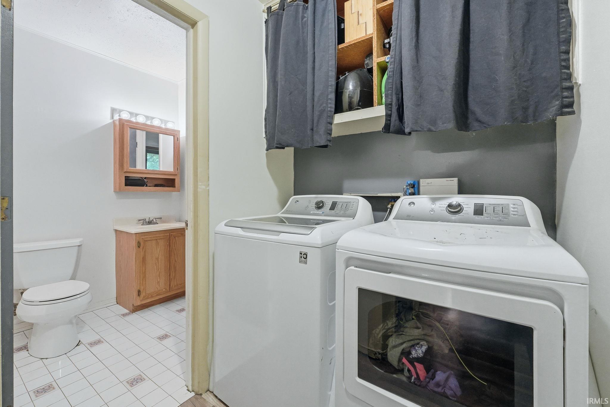 Dedicated laundry area featuring built-in shelving, a washer, and a dryer