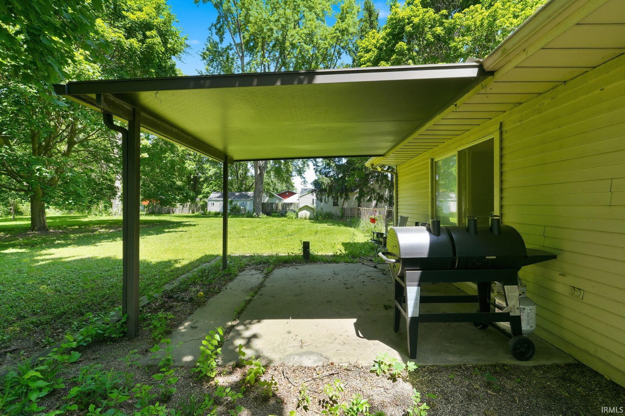 Covered concrete patio with sliding glass door access to the interior