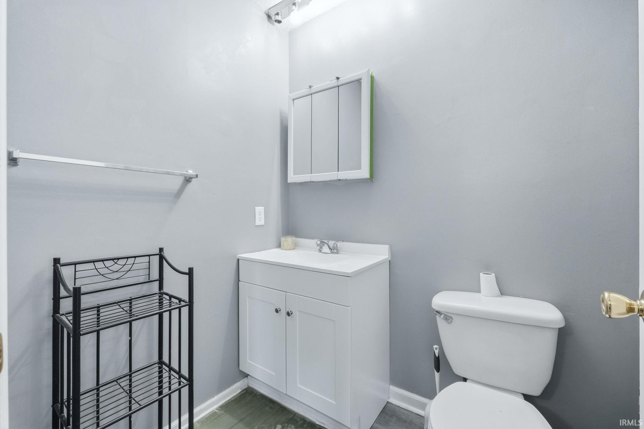 Bathroom featuring a white vanity with integrated sink, white base cabinetry, and a mirrored medicine cabinet