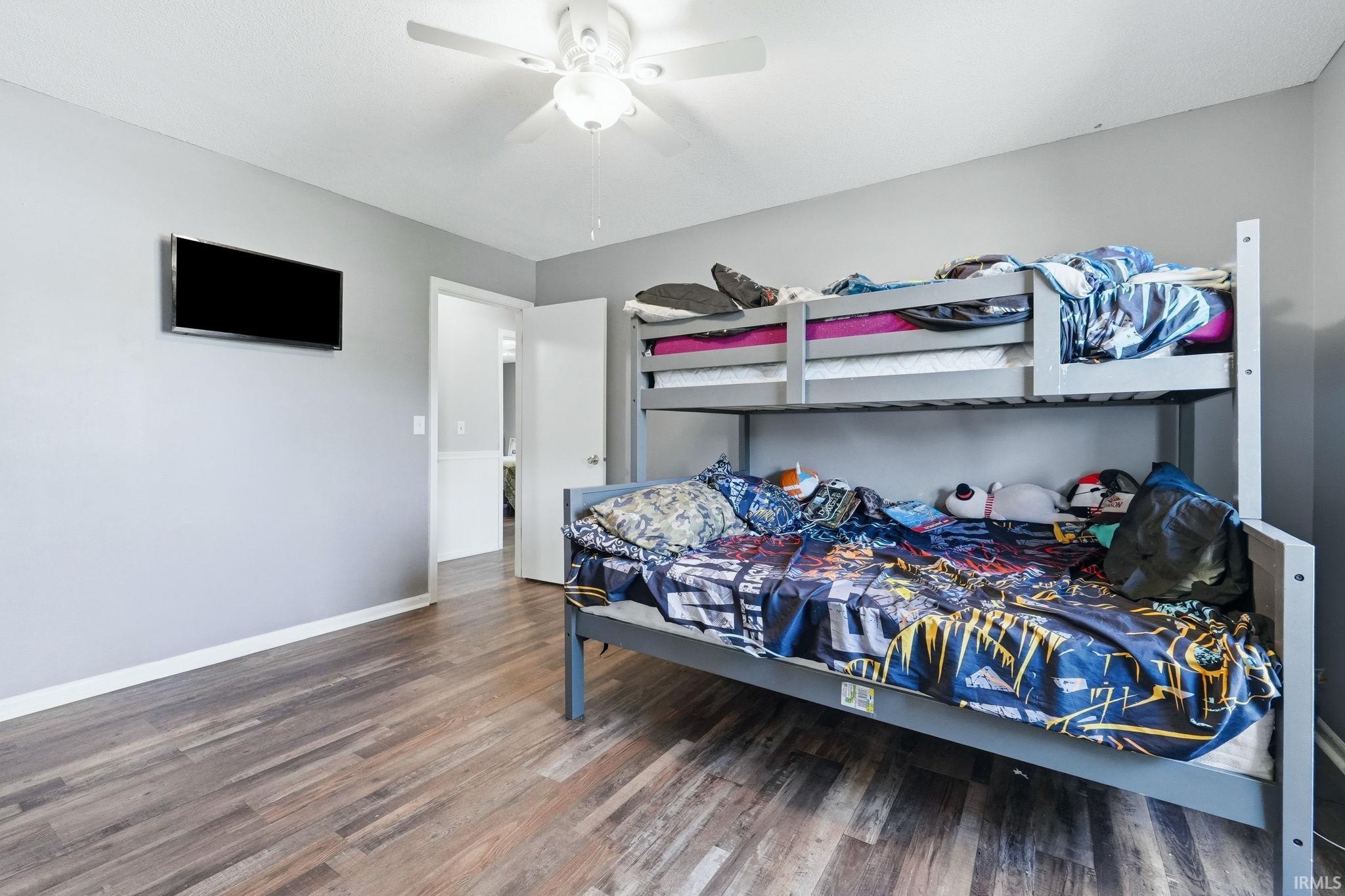Interior room featuring wood-finish flooring, light gray wall paint, and white trim