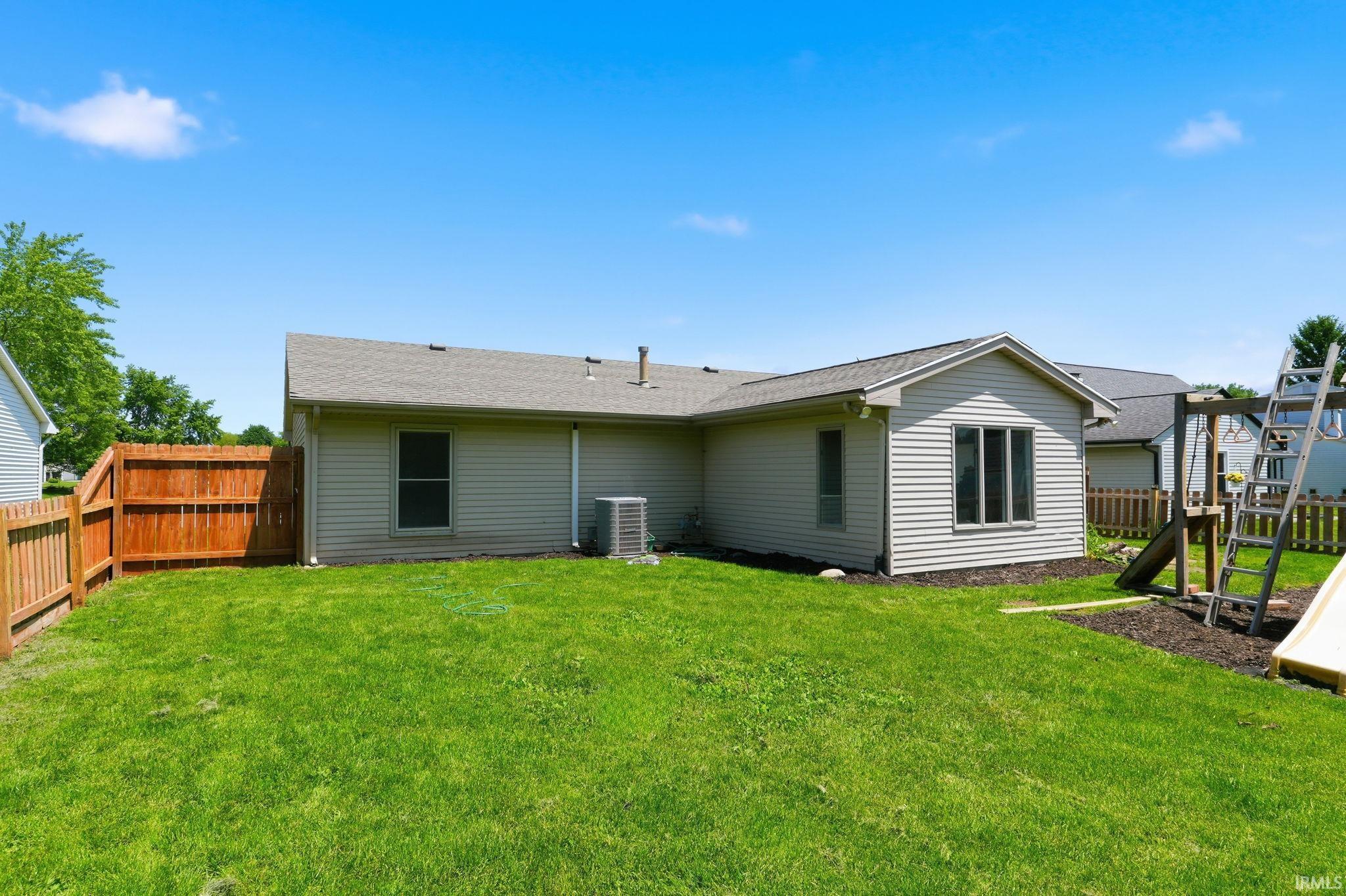 Expansive green lawn with a wood privacy fence