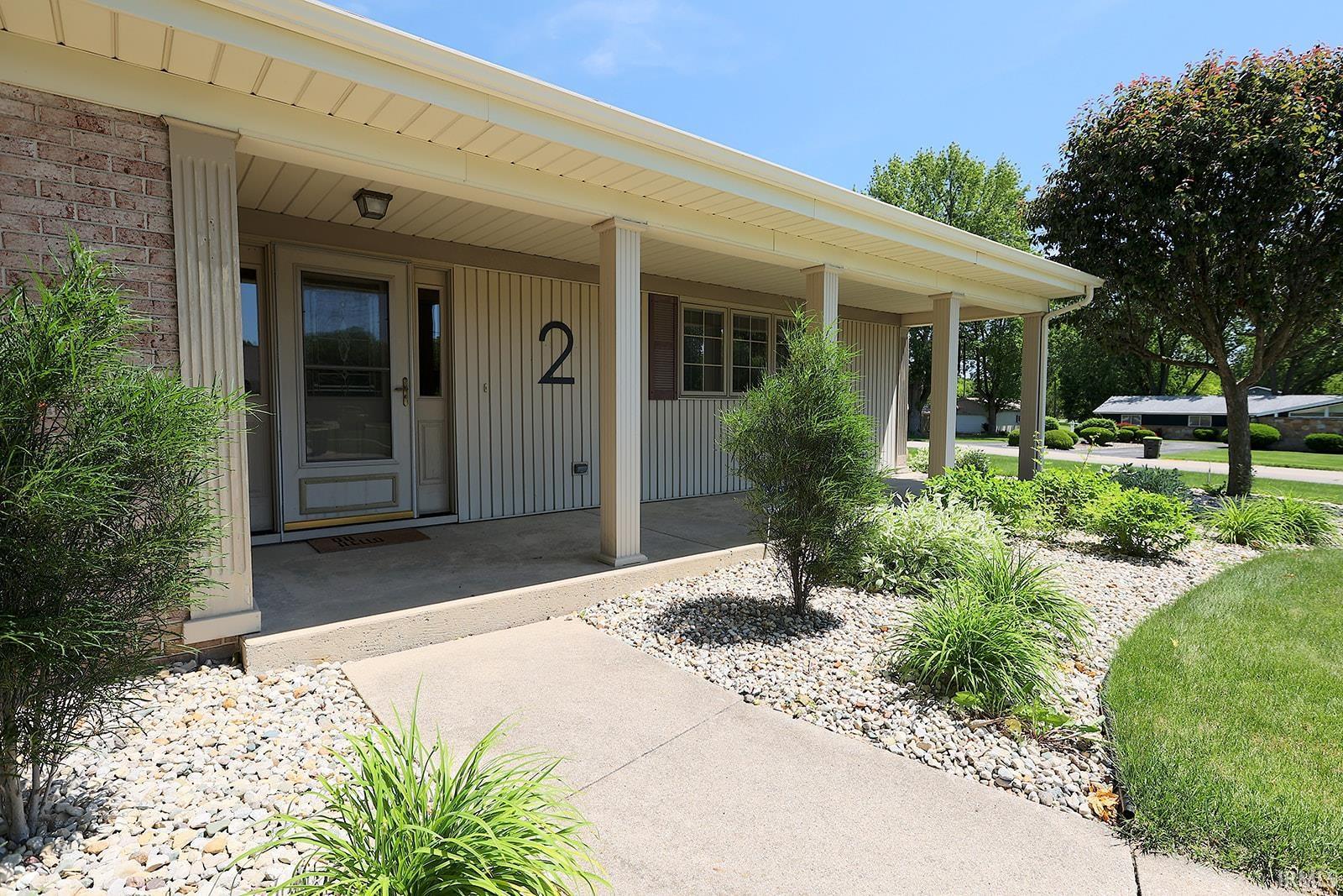Inviting covered porch with architectural columns and a paneled entry door