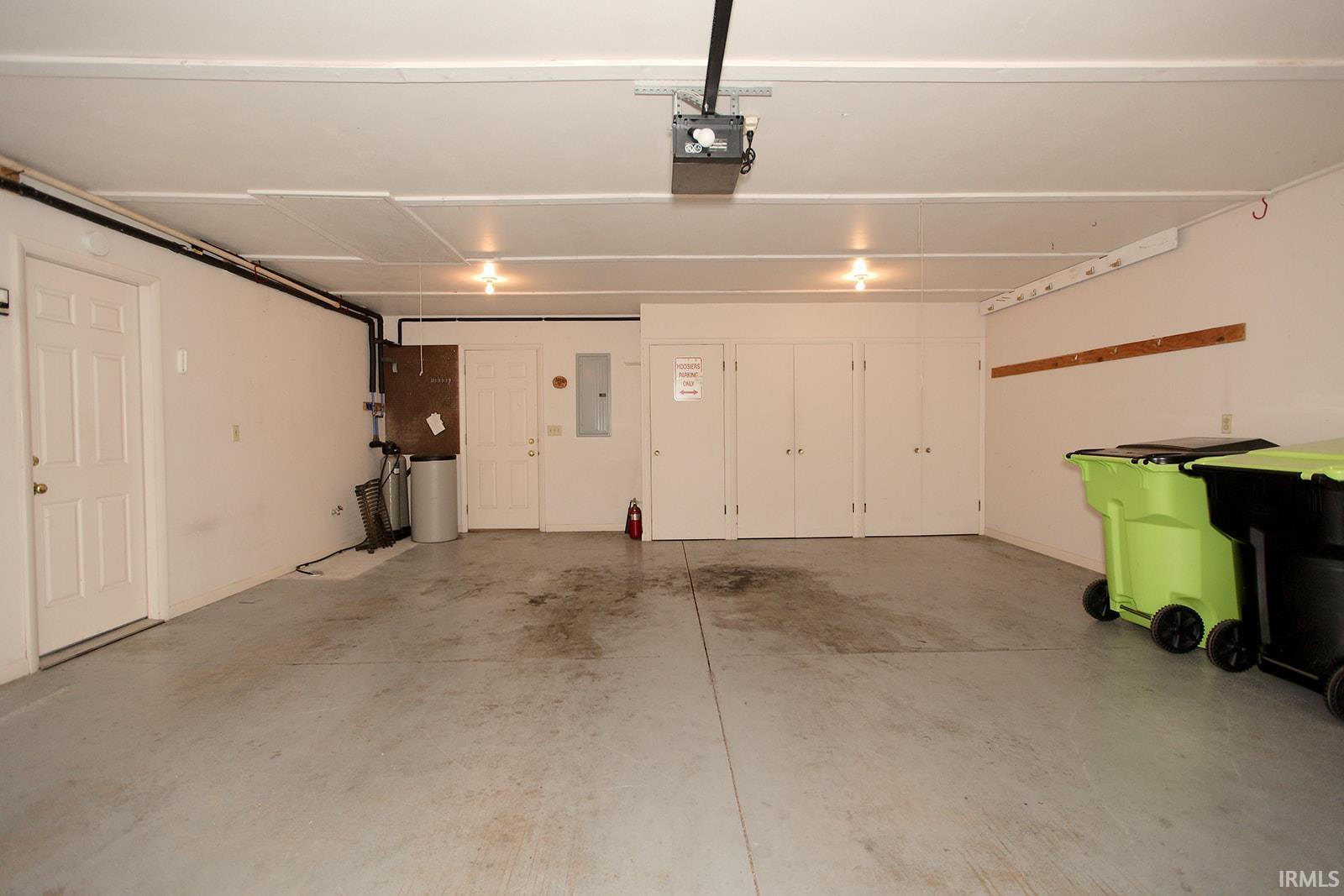 Spacious garage featuring a concrete floor, built-in storage closets, and overhead lighting