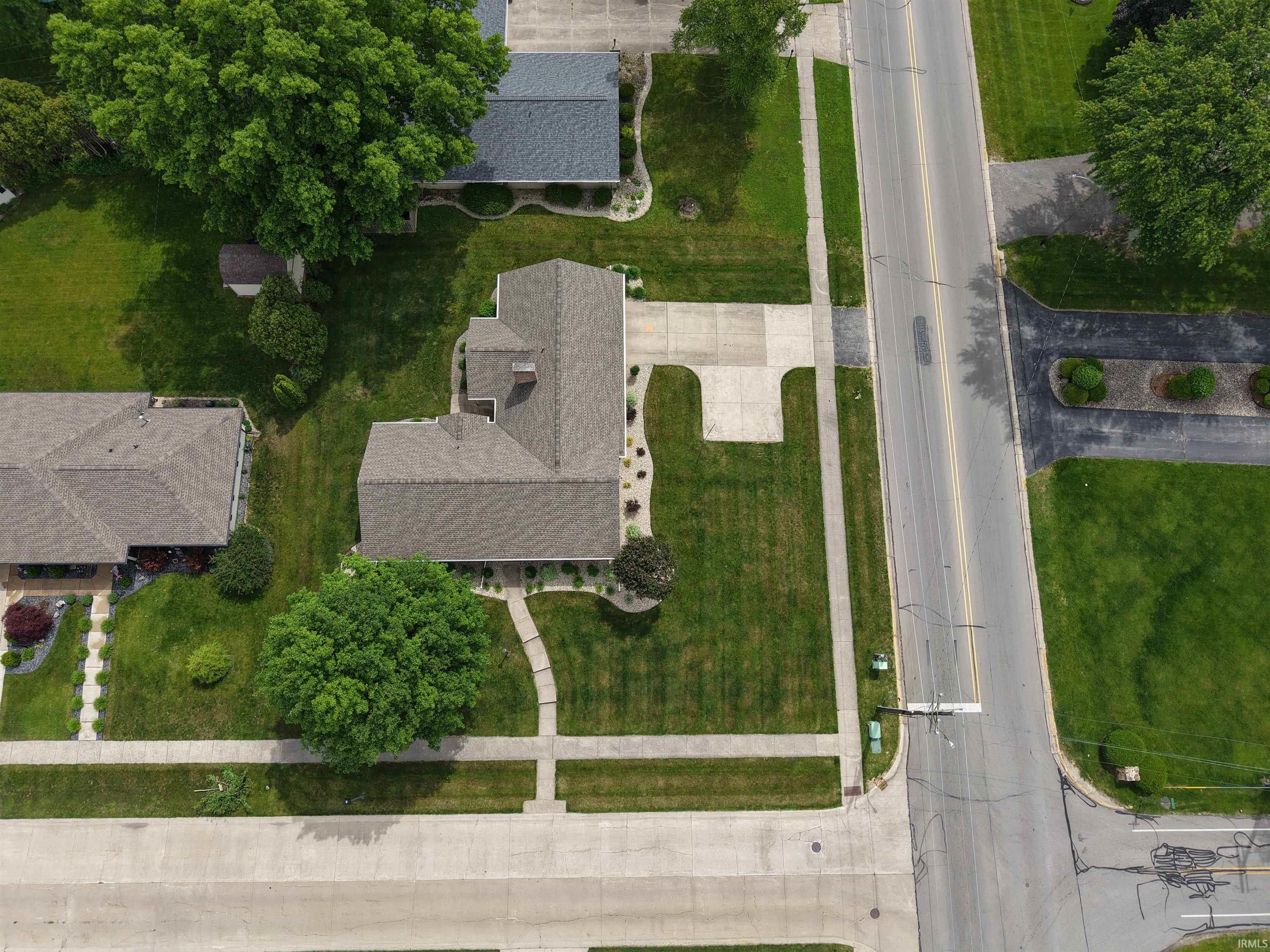 Single-story residence featuring a gray shingle roof and a light-colored driveway