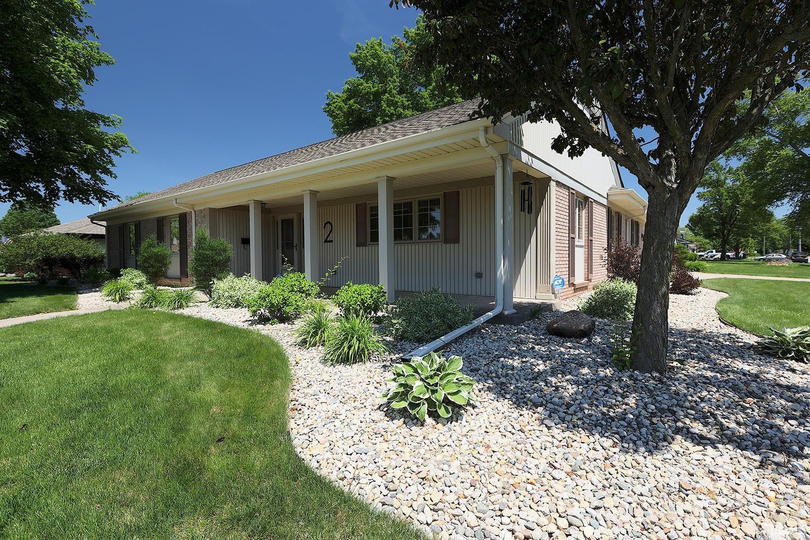 Exterior featuring a covered porch, brick facade accents, and horizontal siding