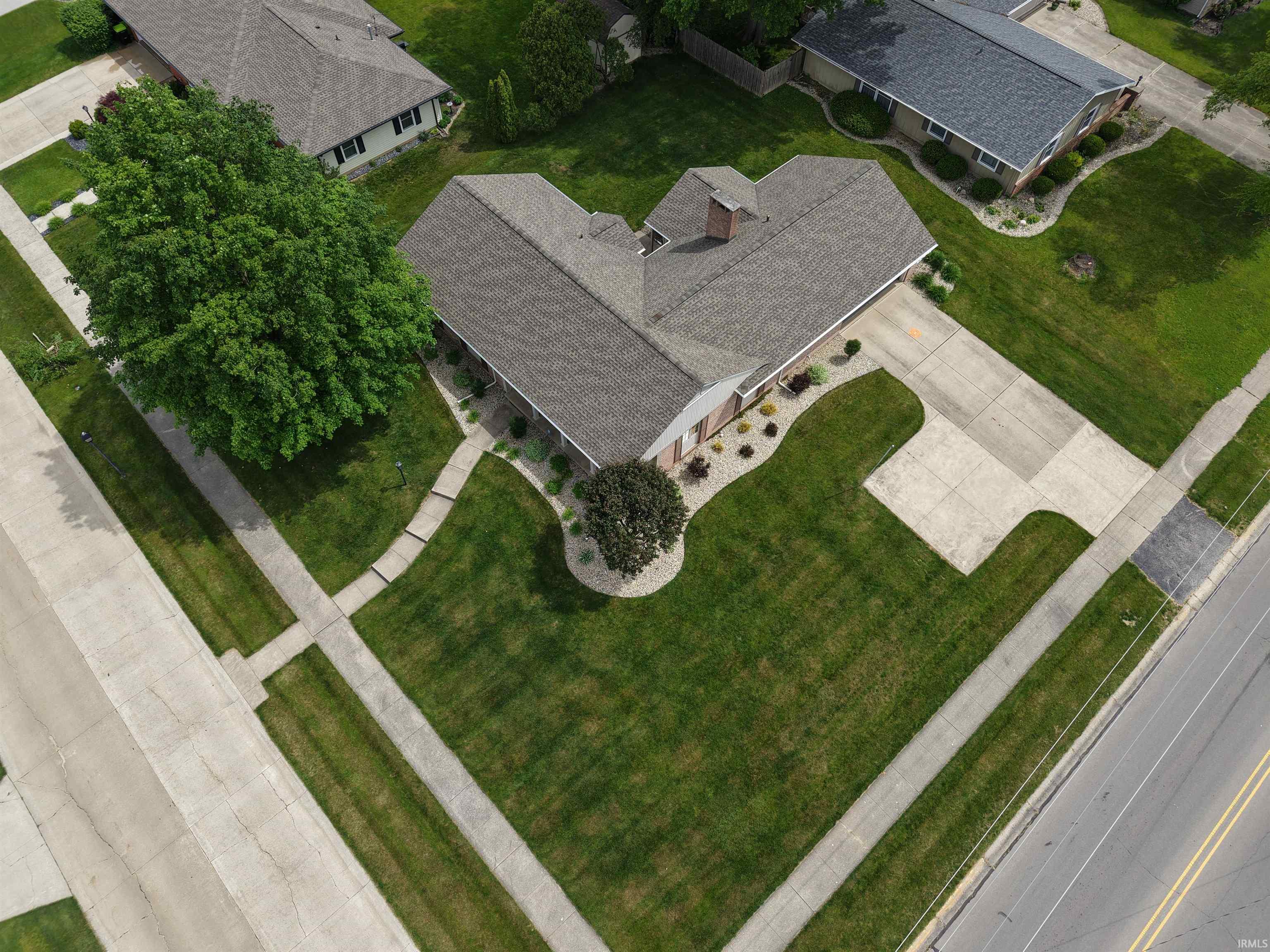 Single-story residence featuring a gray shingle roof and a concrete driveway