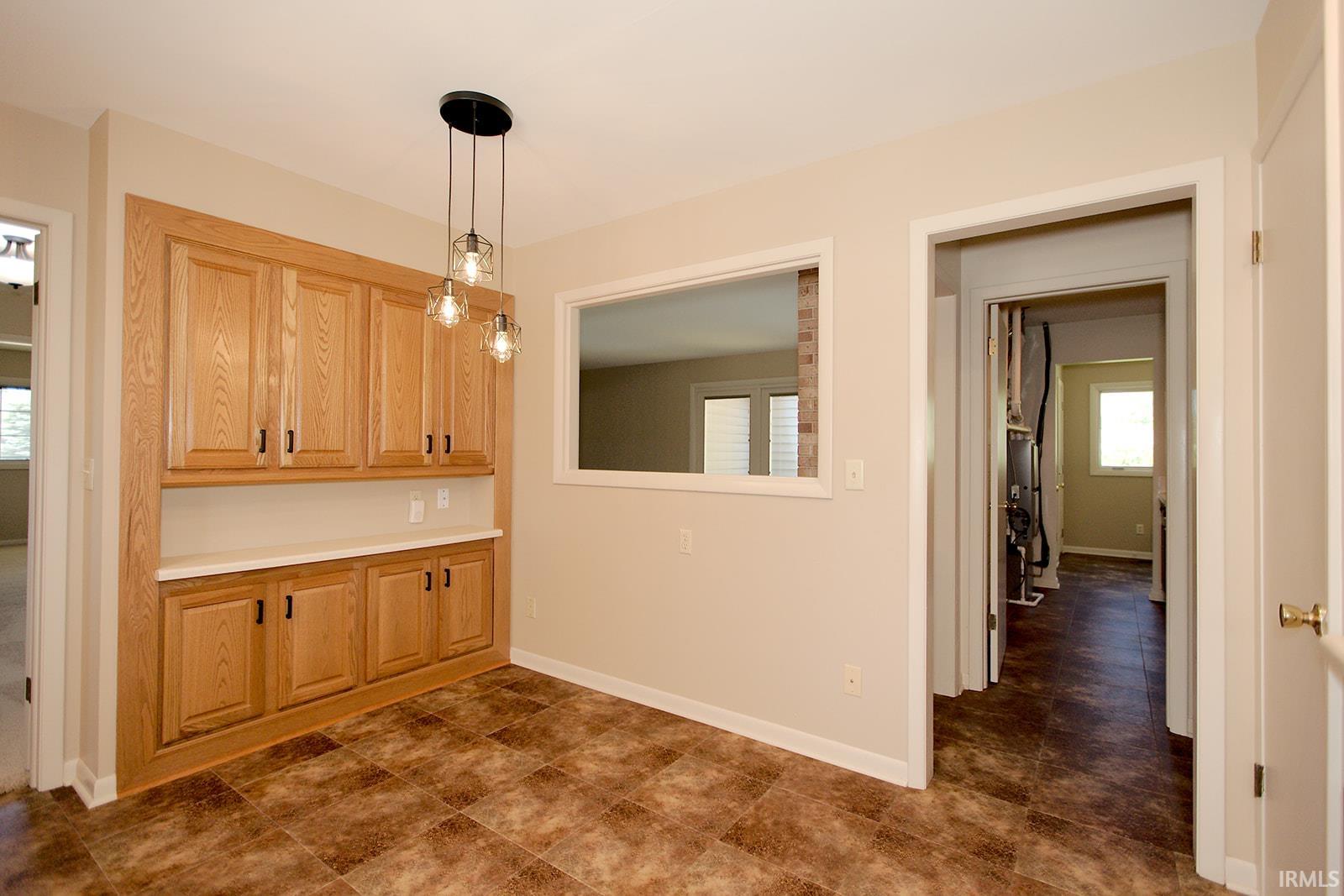 Dining area featuring a built-in wood-finish cabinetry system with a light-toned countertop