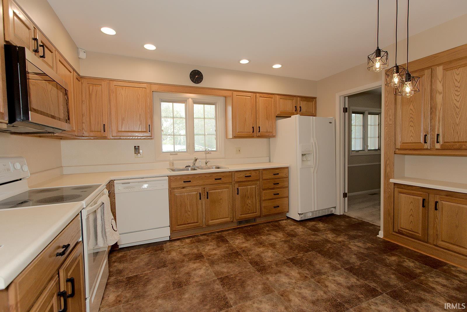 Kitchen featuring wood-finish cabinetry, white countertops, and durable flooring