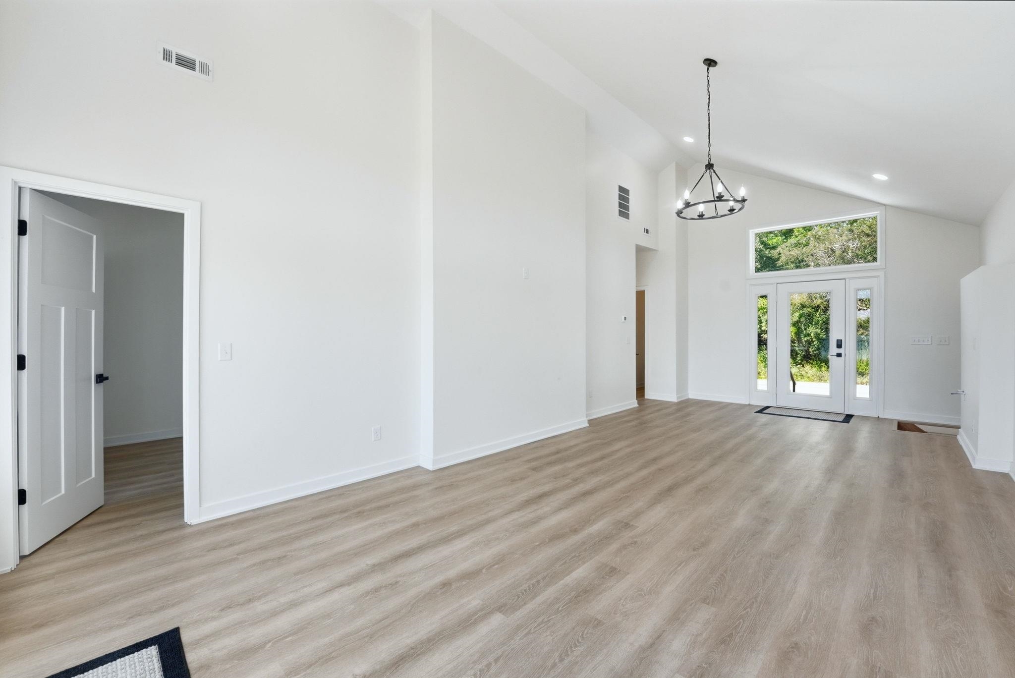 Vaulted ceilings highlight a spacious interior with wood-finish flooring