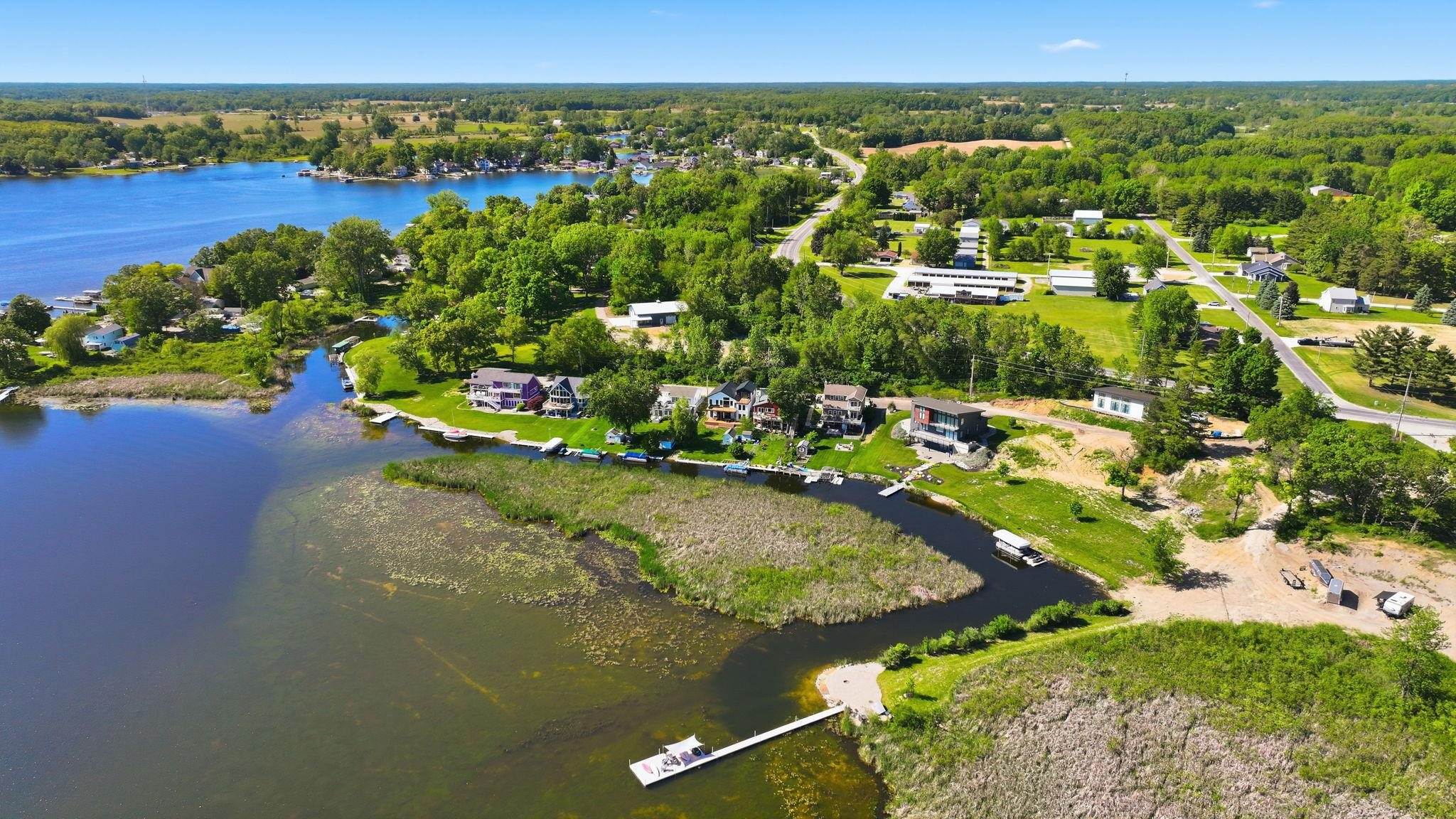 Expansive waterfront property featuring a private dock, direct lake access, and surrounding mature trees