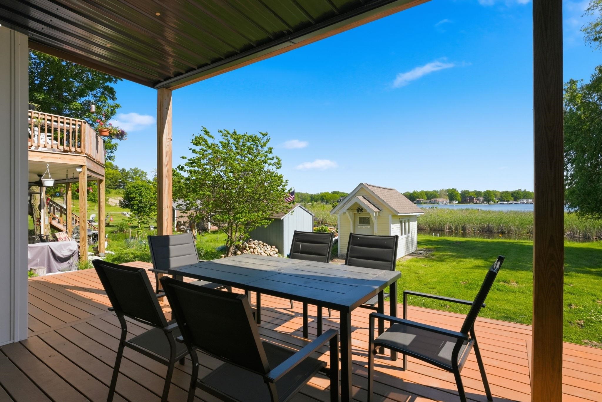 Spacious covered deck featuring composite decking, wood support columns, and a metal roof