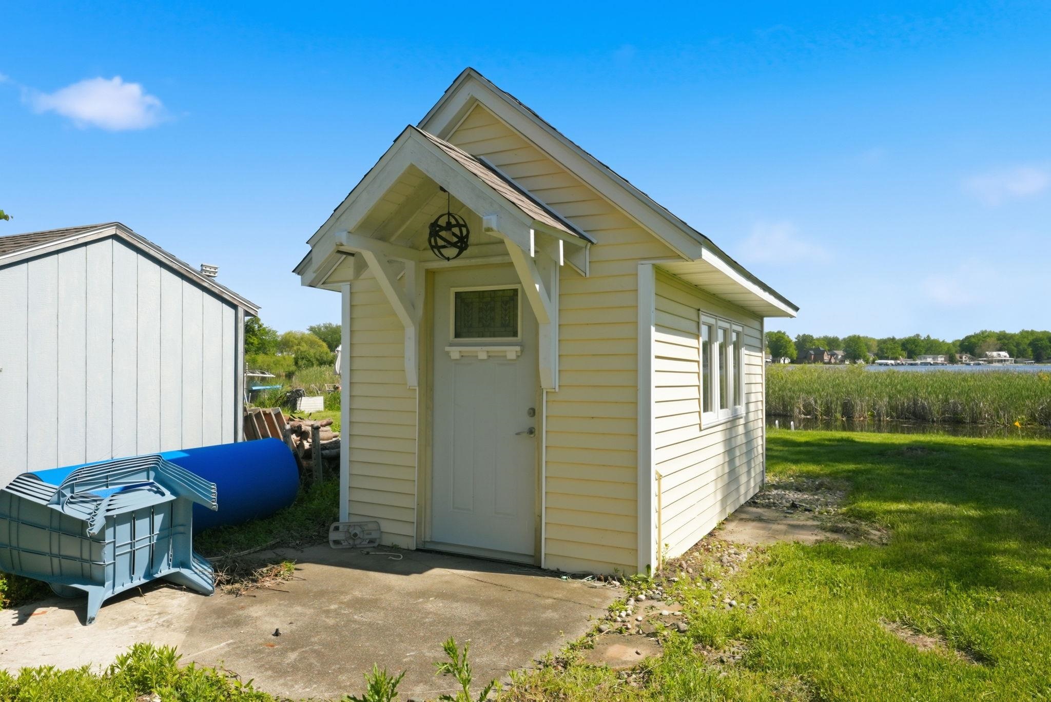 Waterfront structure featuring light-colored siding and a covered entry
