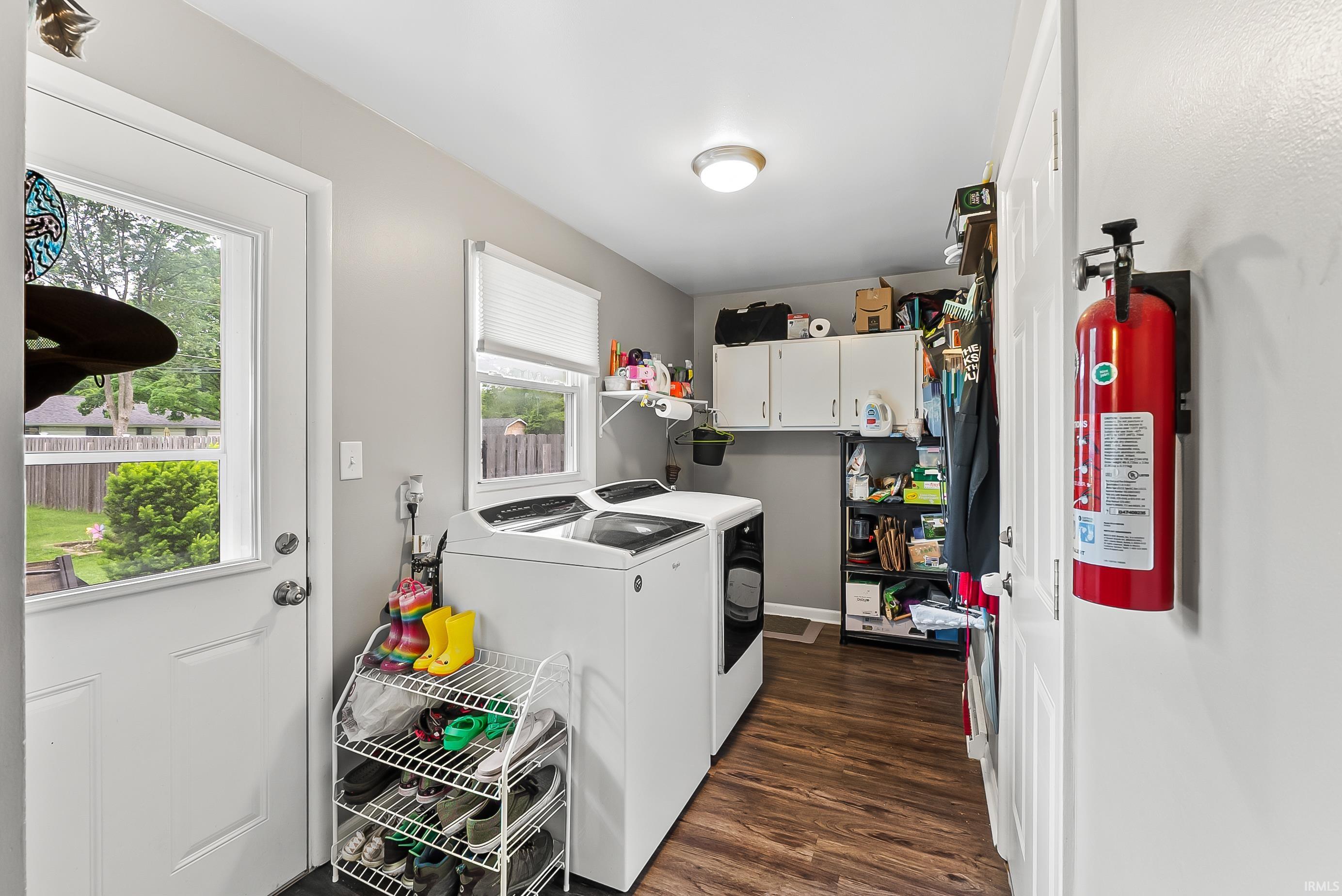 Laundry room featuring wood-finish flooring and a white exterior door with a glass panel