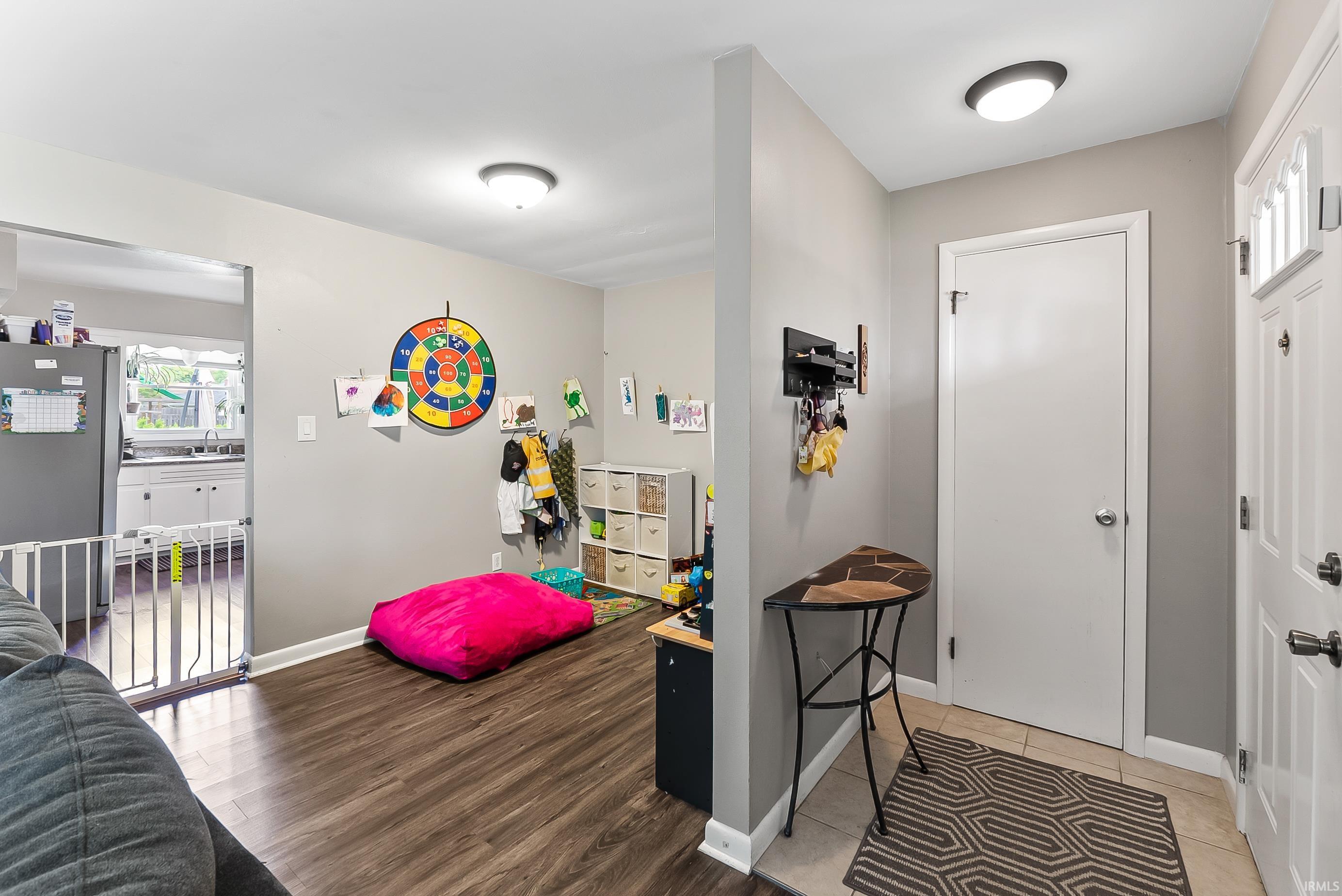 Inviting entryway featuring a white paneled door with glass inserts, neutral wall color, and tile flooring