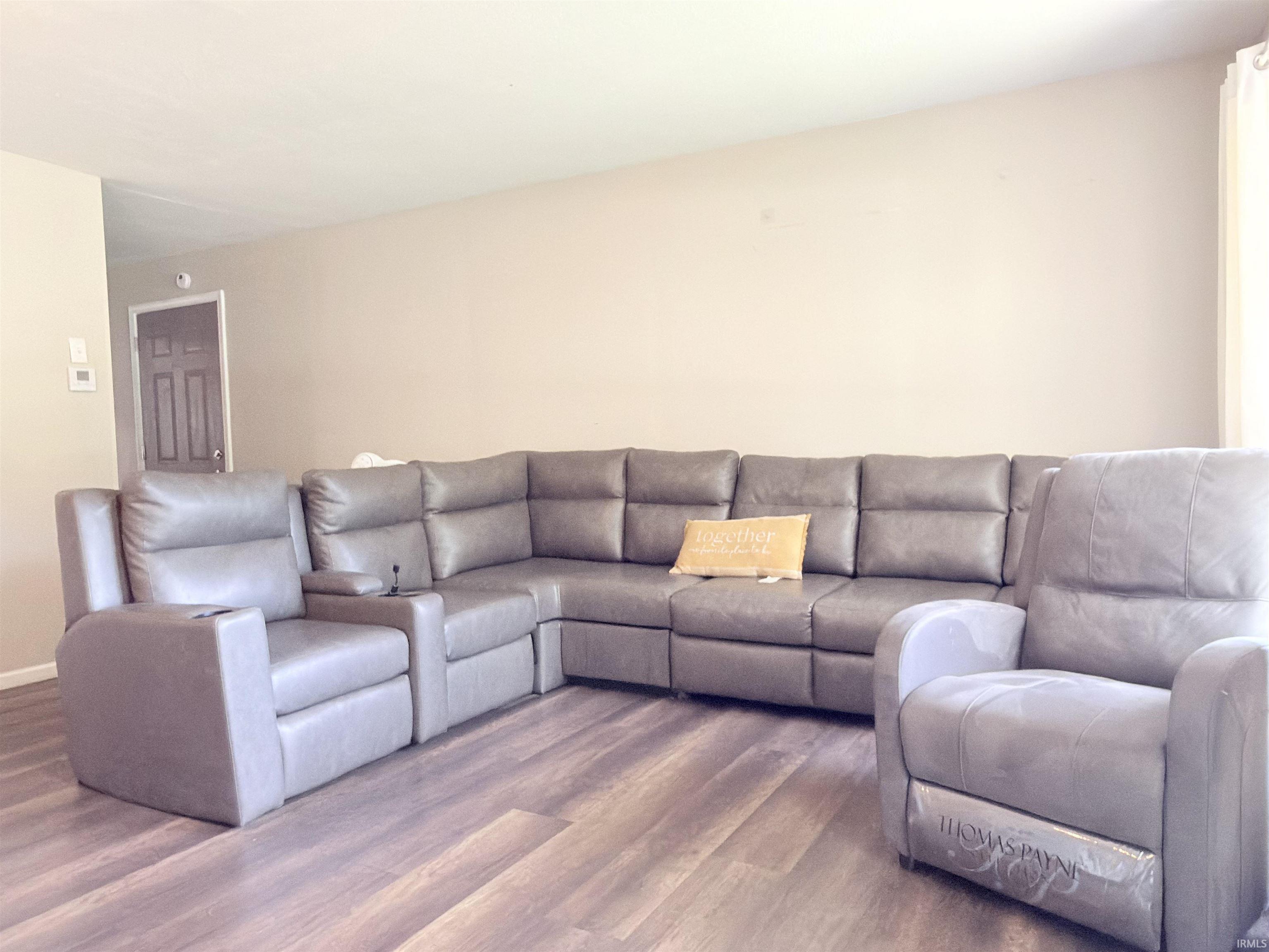 Spacious room featuring wood-finish flooring and neutral wall tones