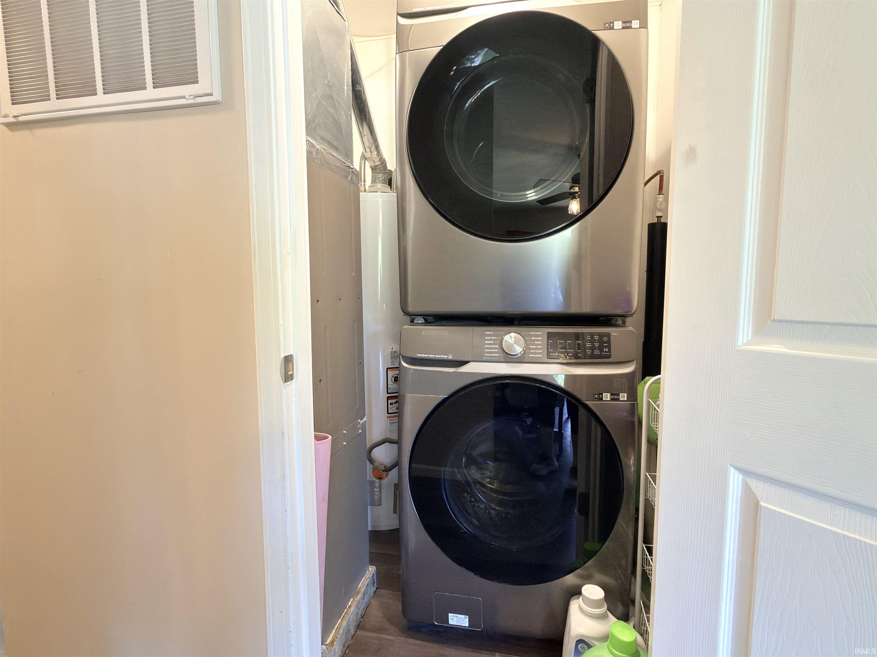 Dedicated laundry area featuring stacked stainless steel appliances