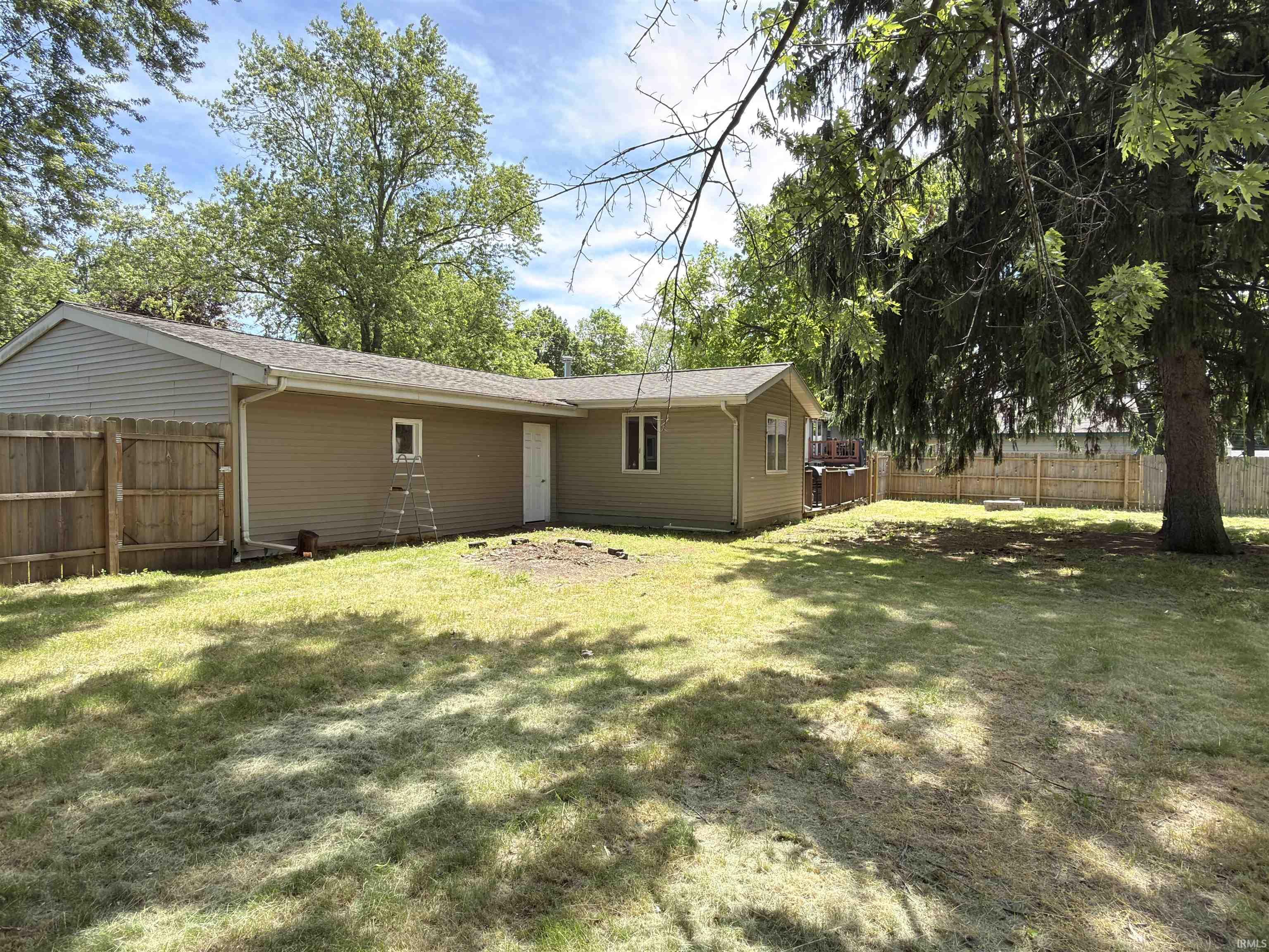 Expansive green space featuring perimeter fencing and mature trees