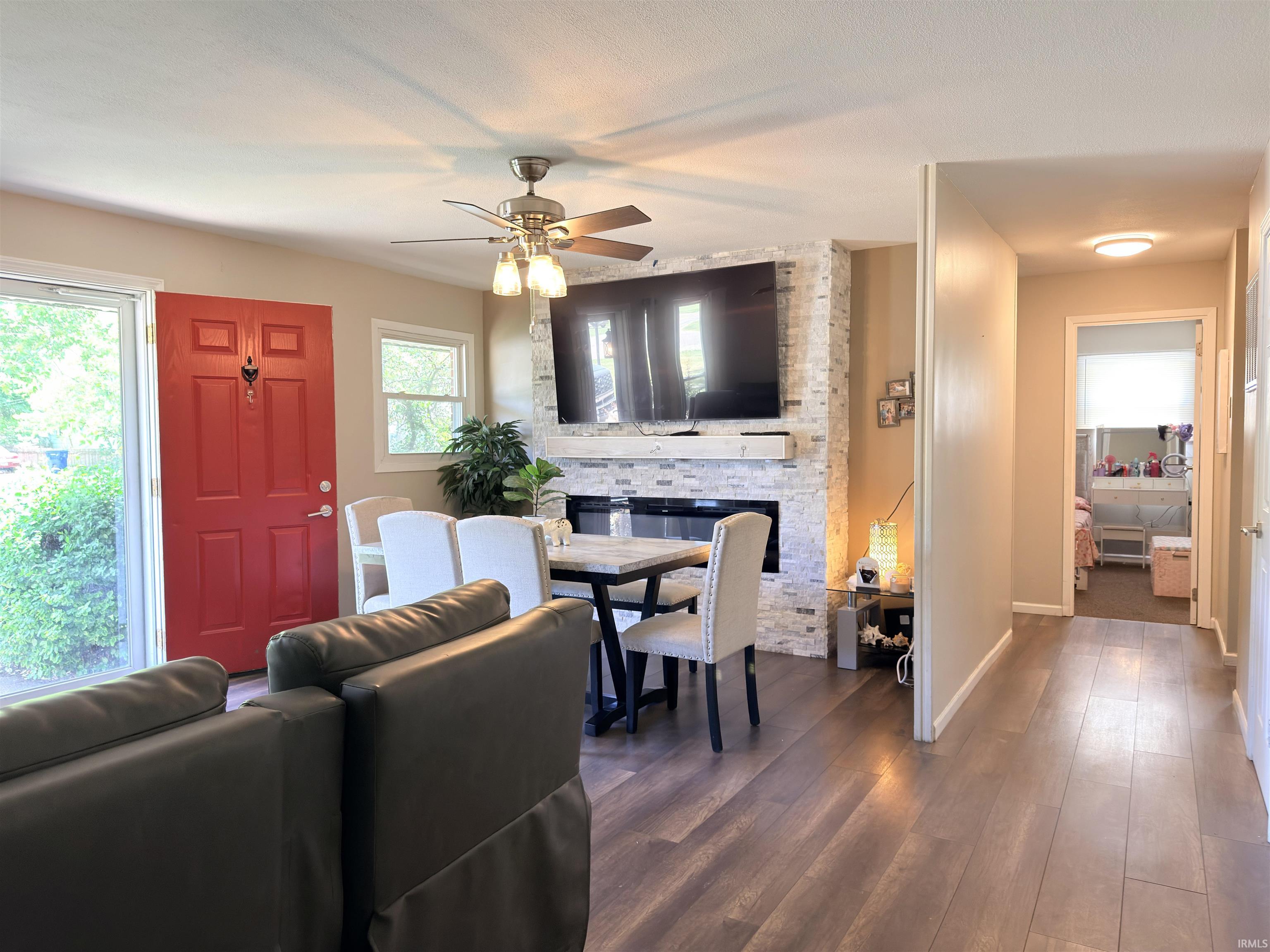 Living area featuring wood-finish flooring and a red entry door