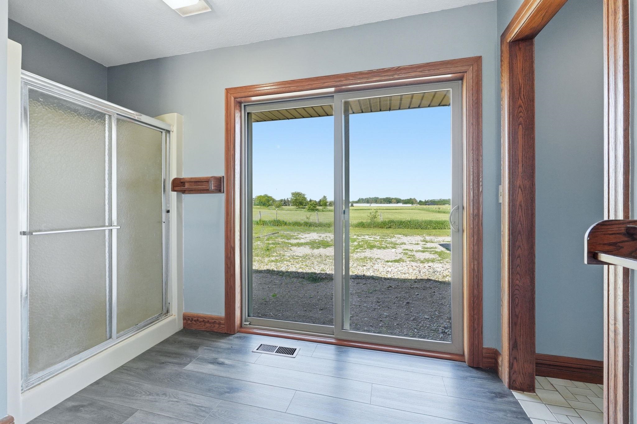 Sliding glass patio door with wood-finish trim, offering expansive exterior views