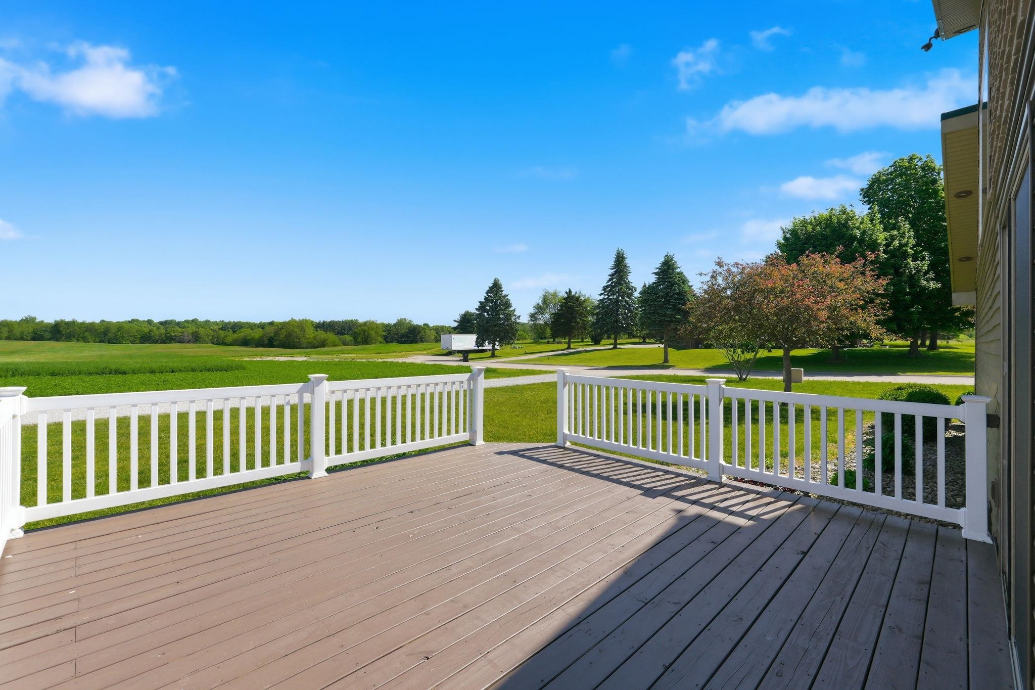 Spacious outdoor deck with composite wood-finish flooring and white railing