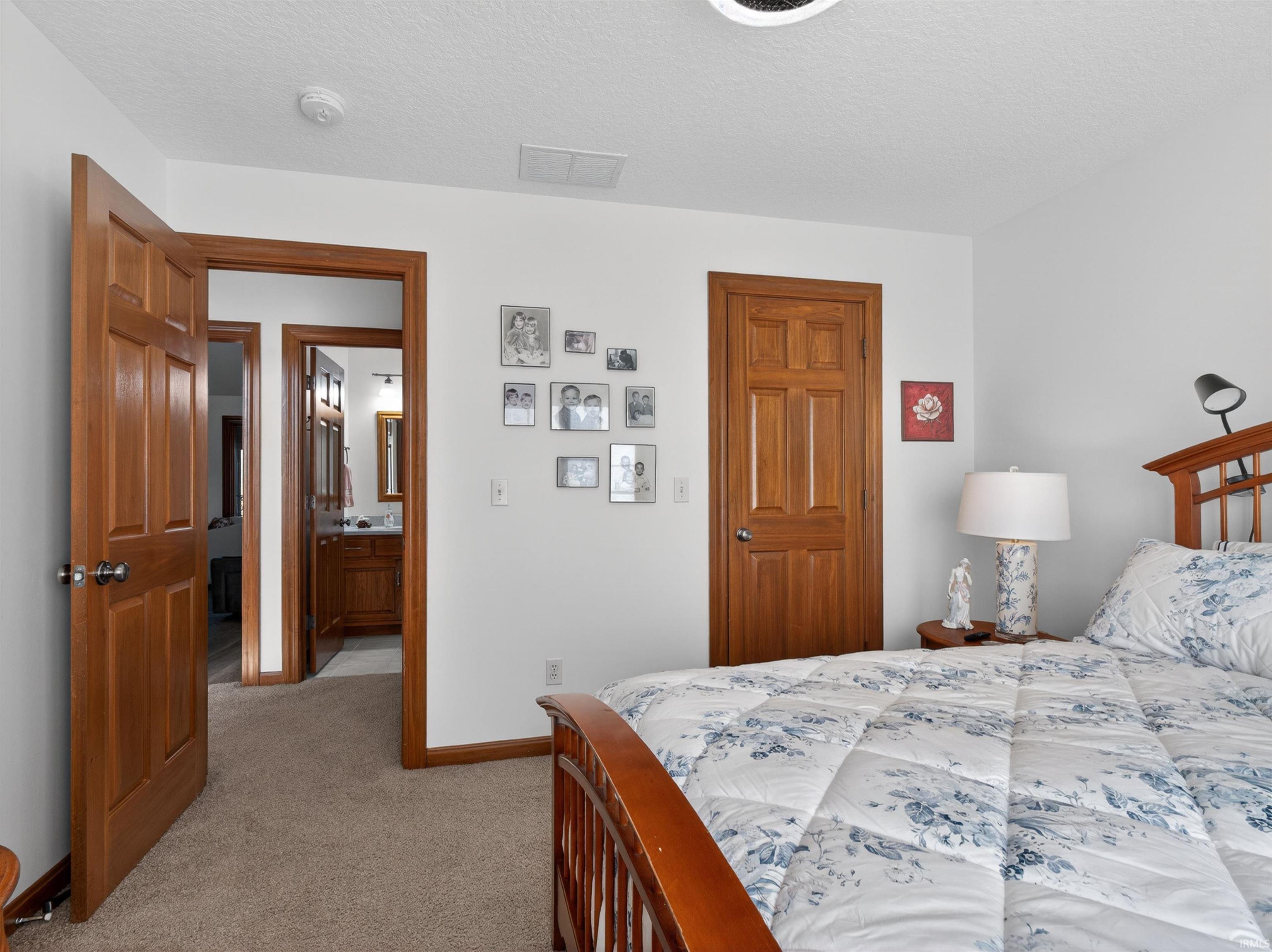 Carpeted BEDROOM, WALK IN CLOSET, CUSTOM SHELVING, CUSTOM BLINDS.