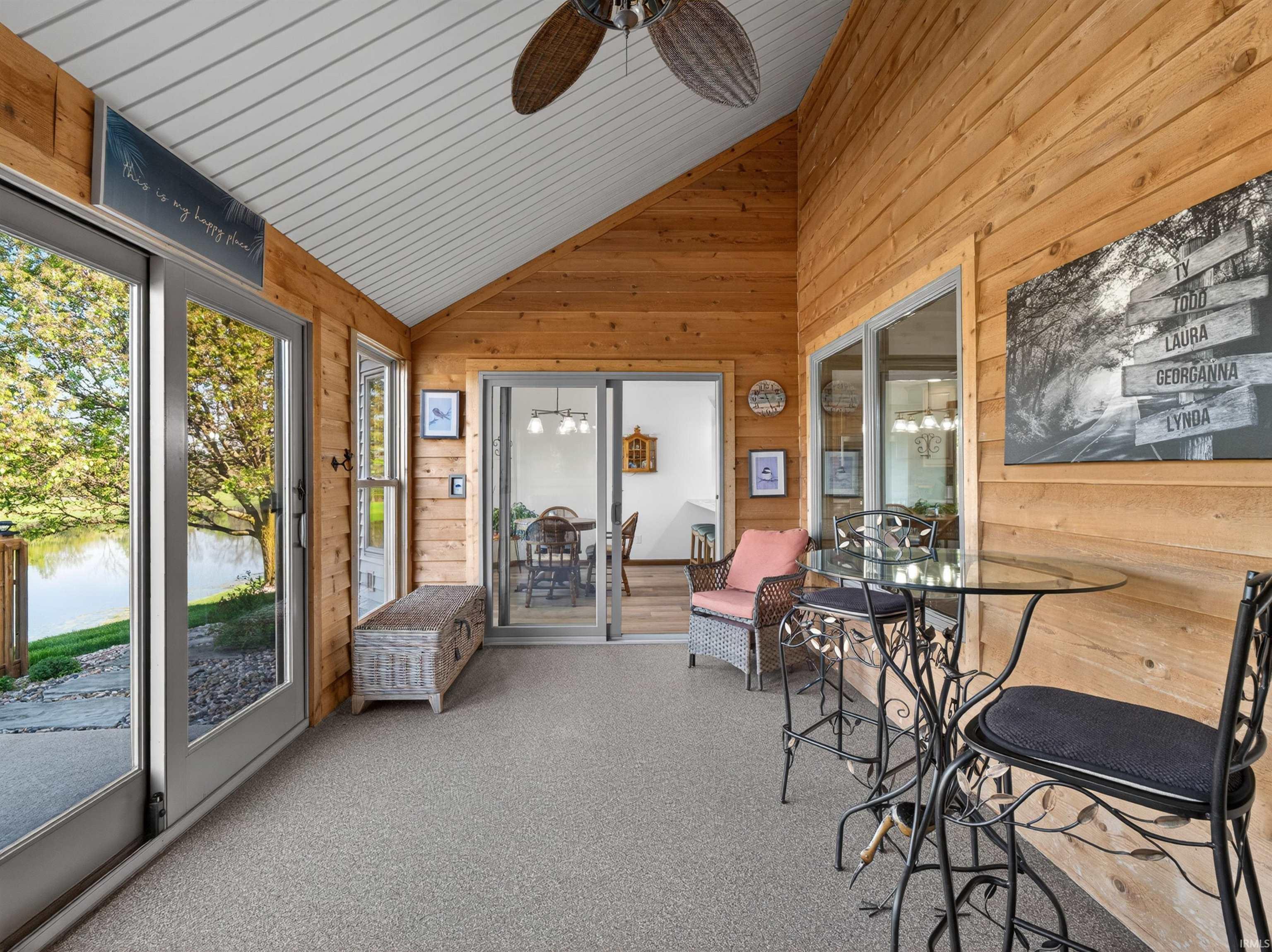 Enclosed patio SUNROOM featuring CEDAR paneling, vaulted vinyl ceiling, ceiling fan, single hung windows, Anderson sliding patio door with foot lock and screen.