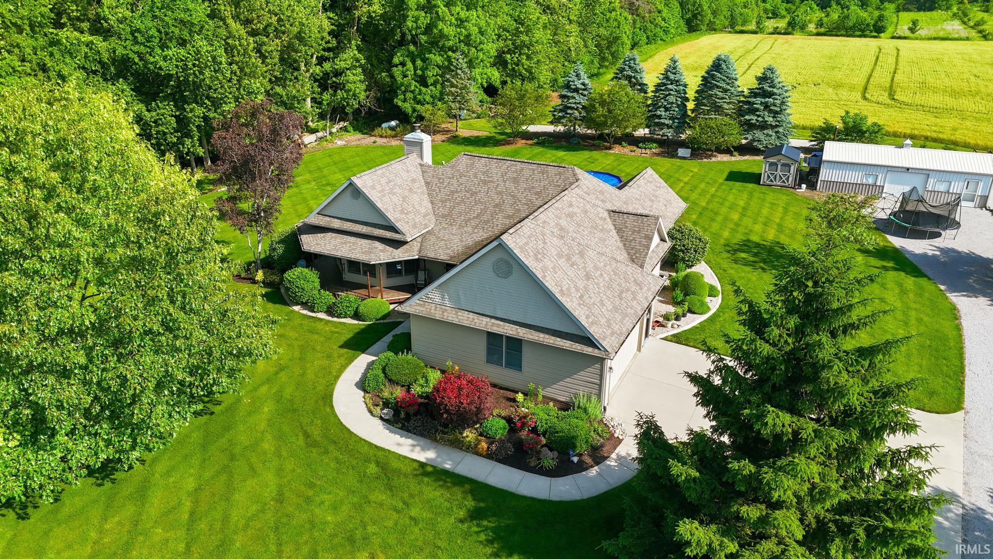 Expansive property featuring a residence with a multi-gabled roof and a light-colored exterior