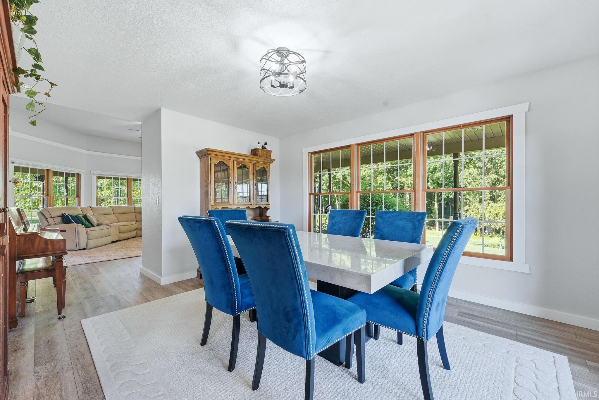 Dining area featuring wood-finish flooring, a contemporary light fixture, and a built-in display cabinet