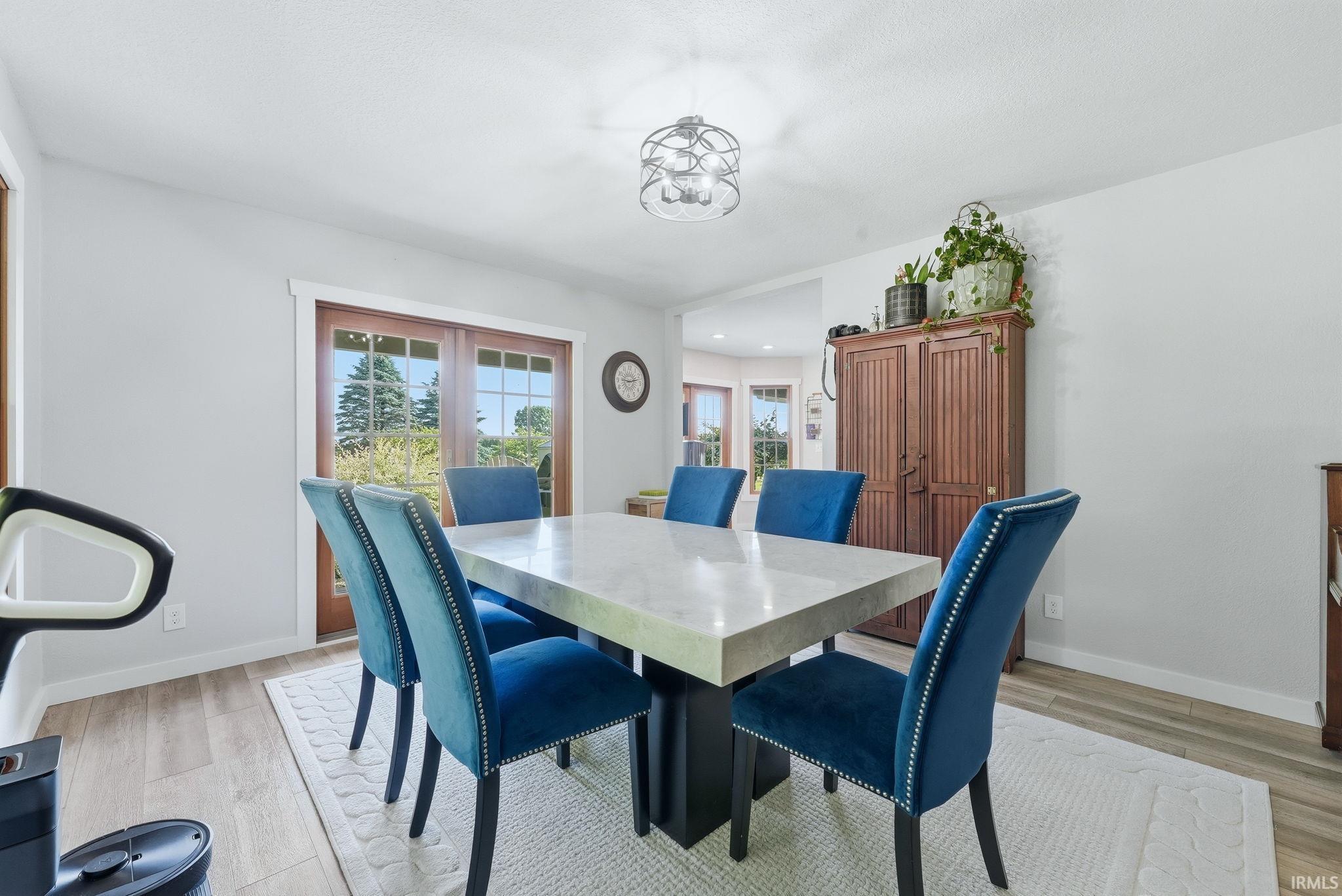 Dining area with wood-finish flooring and light-toned walls