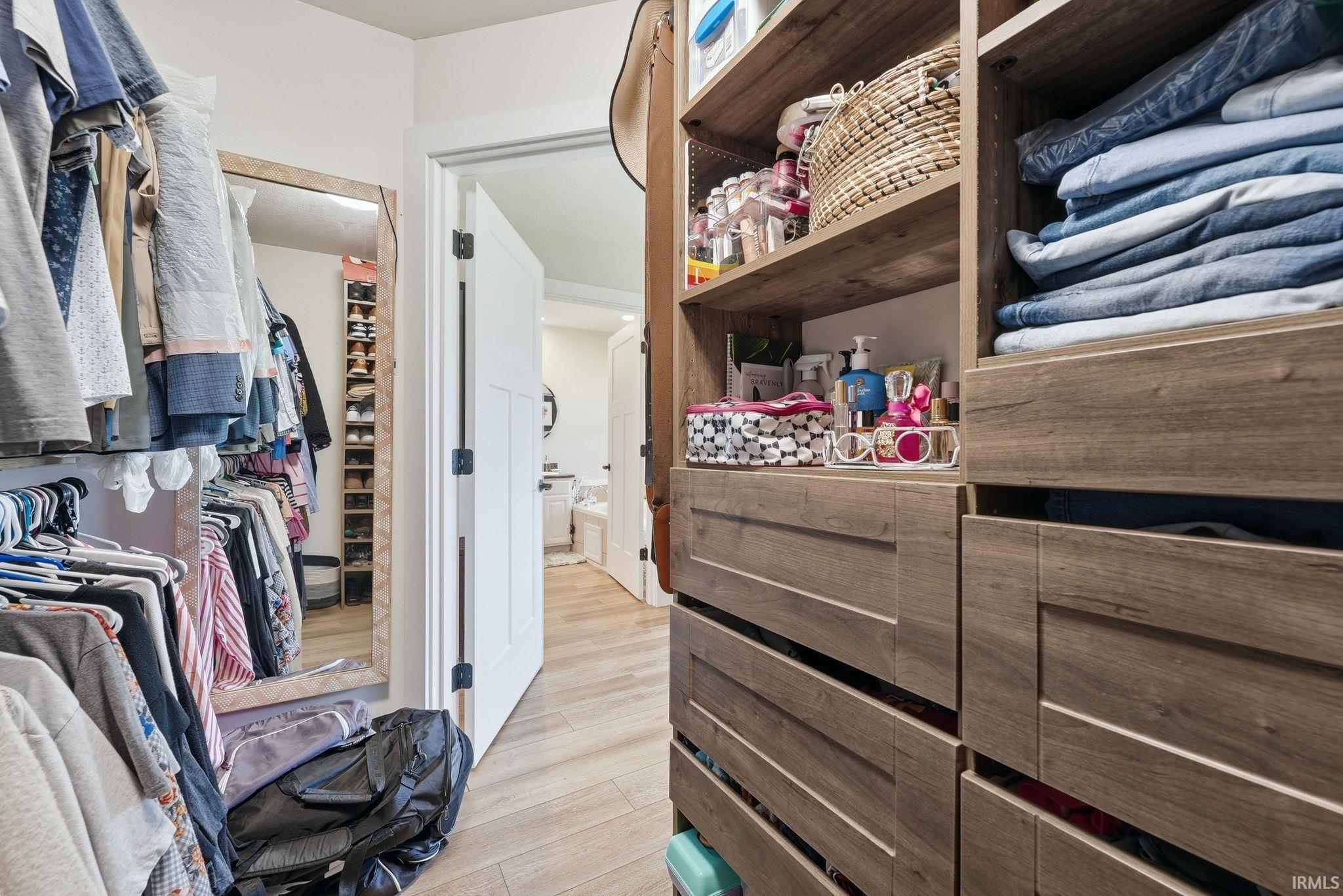 Custom closet system featuring wood-finish cabinetry and drawers