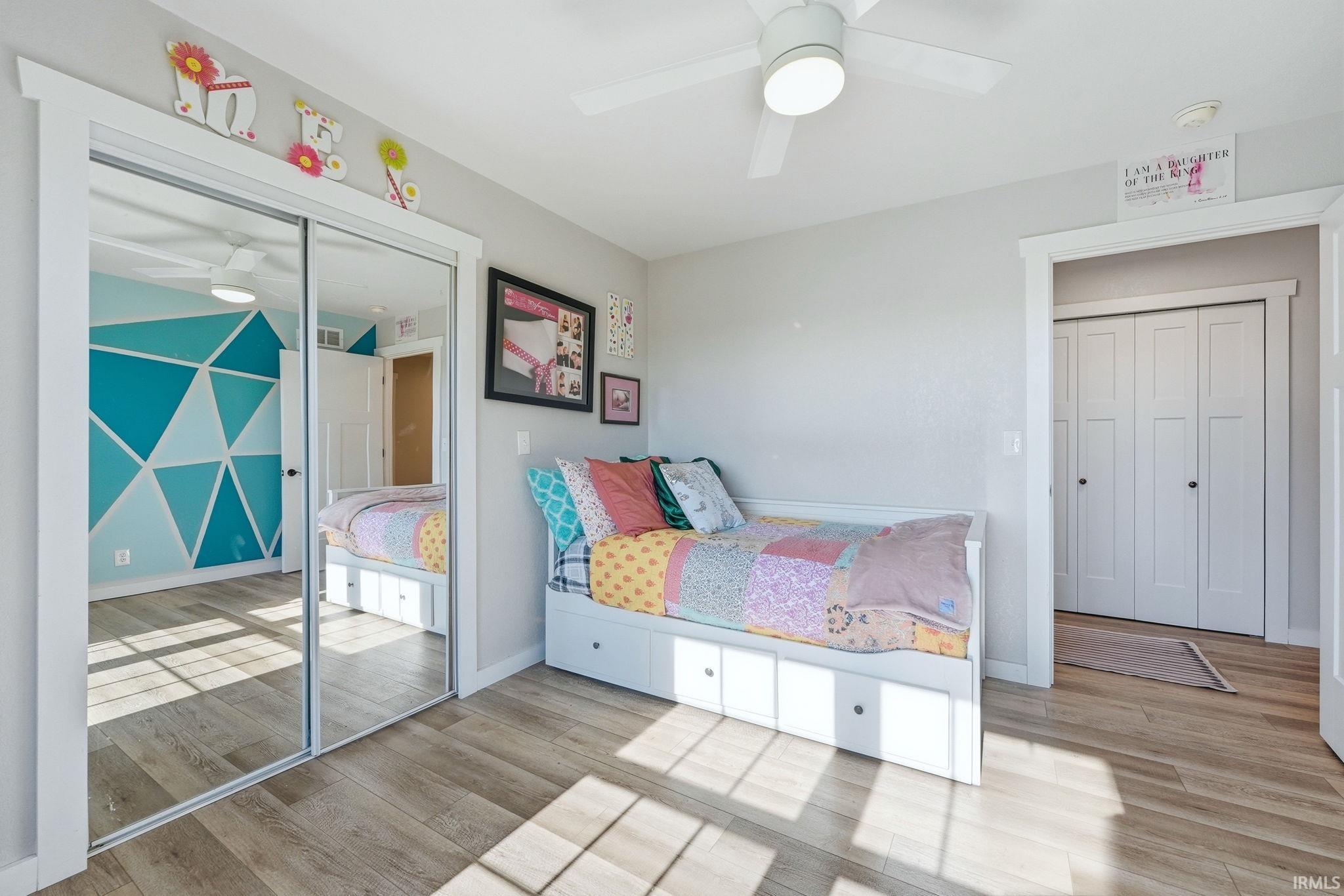 Interior room featuring wood-finish flooring and a ceiling fan with integrated lighting