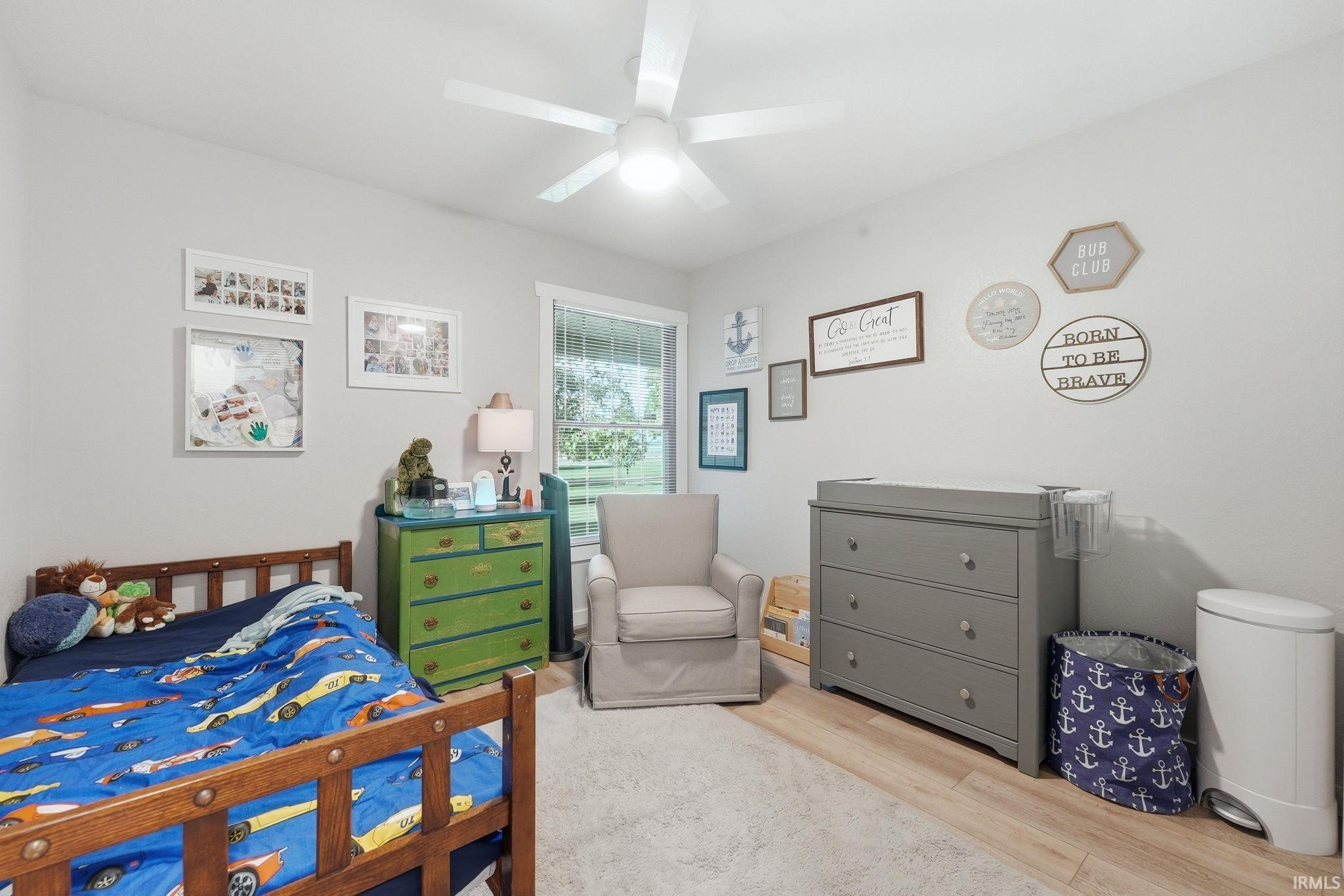 Neutral wall paint with white trim, wood-finish flooring, and a ceiling fan with integrated lighting